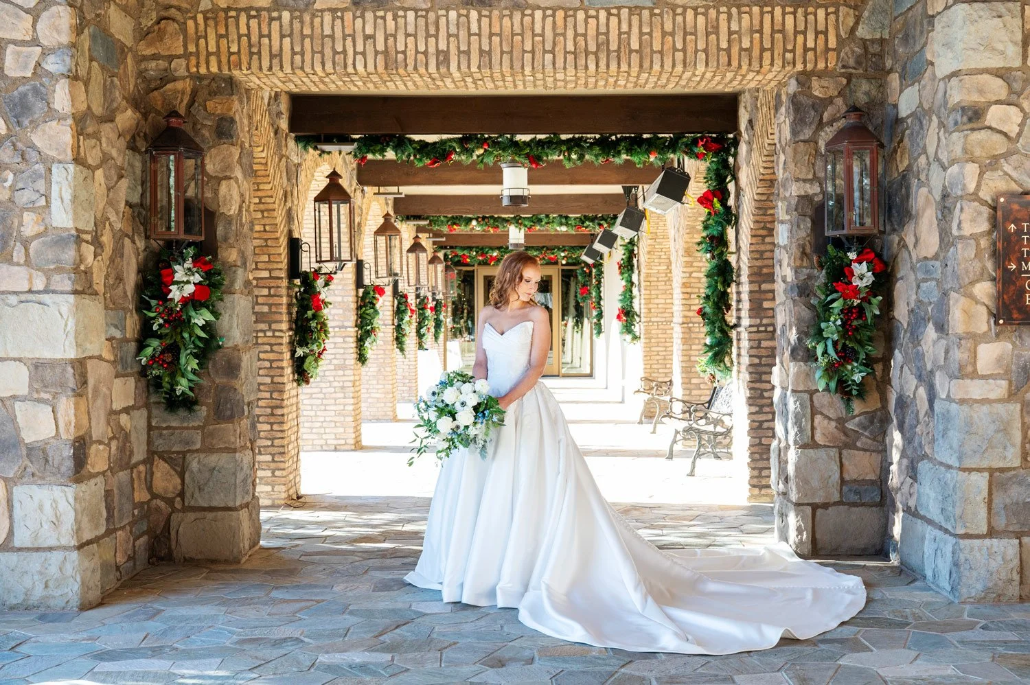 bride with her bouquet standing in the brick entrance to the clubhouse