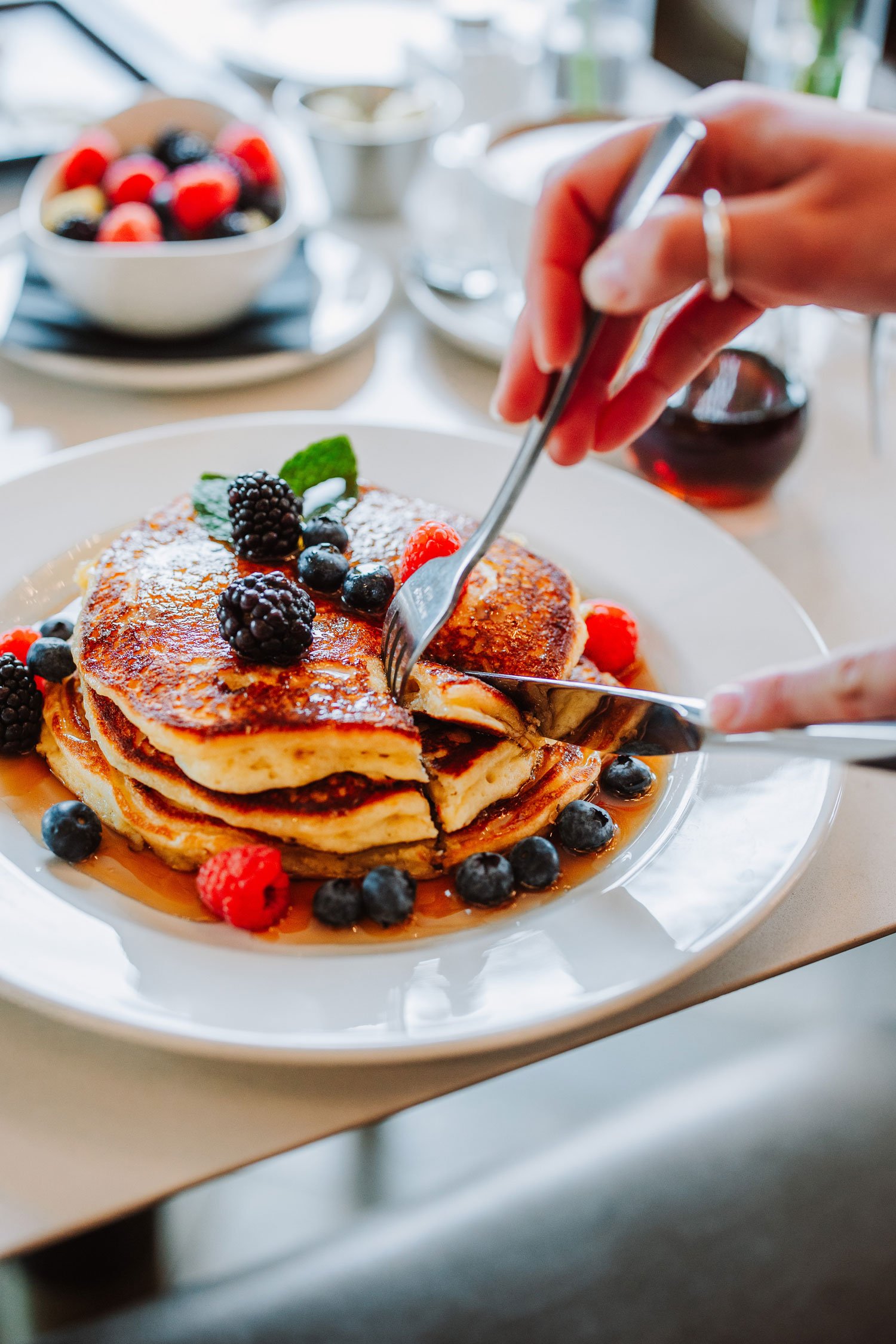 breakfast stack of pancakes with syrup and fruit toppings at fortezzas lobby bar