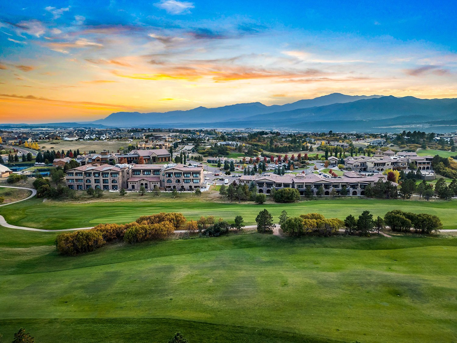 exterior aerial image of the hotel and golf course at sunset