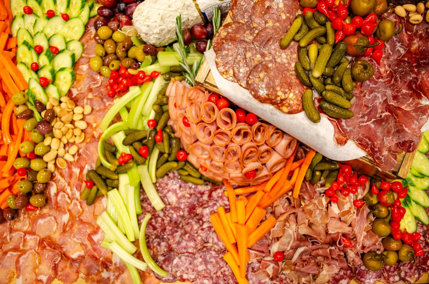 charcuterie meats cheeses and assortment of vegetables and pickled vegetables