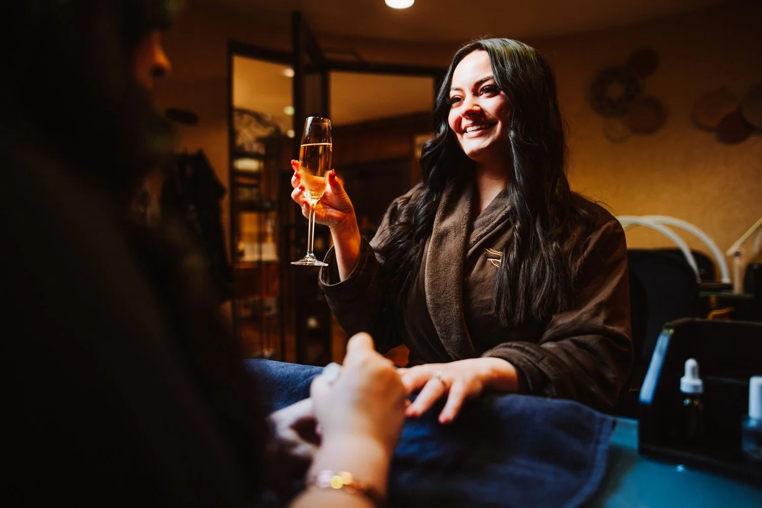 couple sitting in spa robes with glass of champagne
