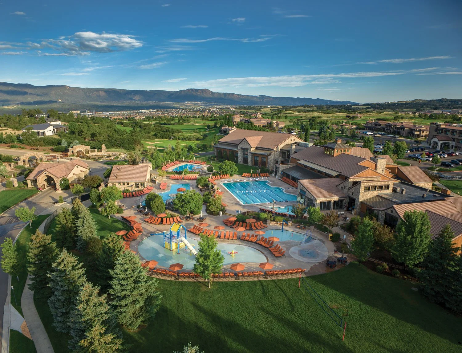 aerial image of the pools during summer time with views of the mountains
