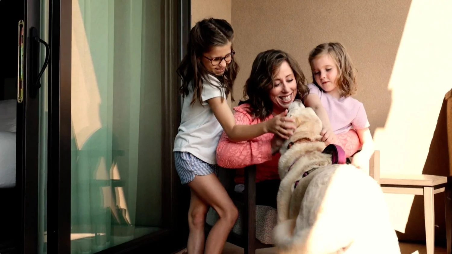 mom and daughters with their dog on the patio