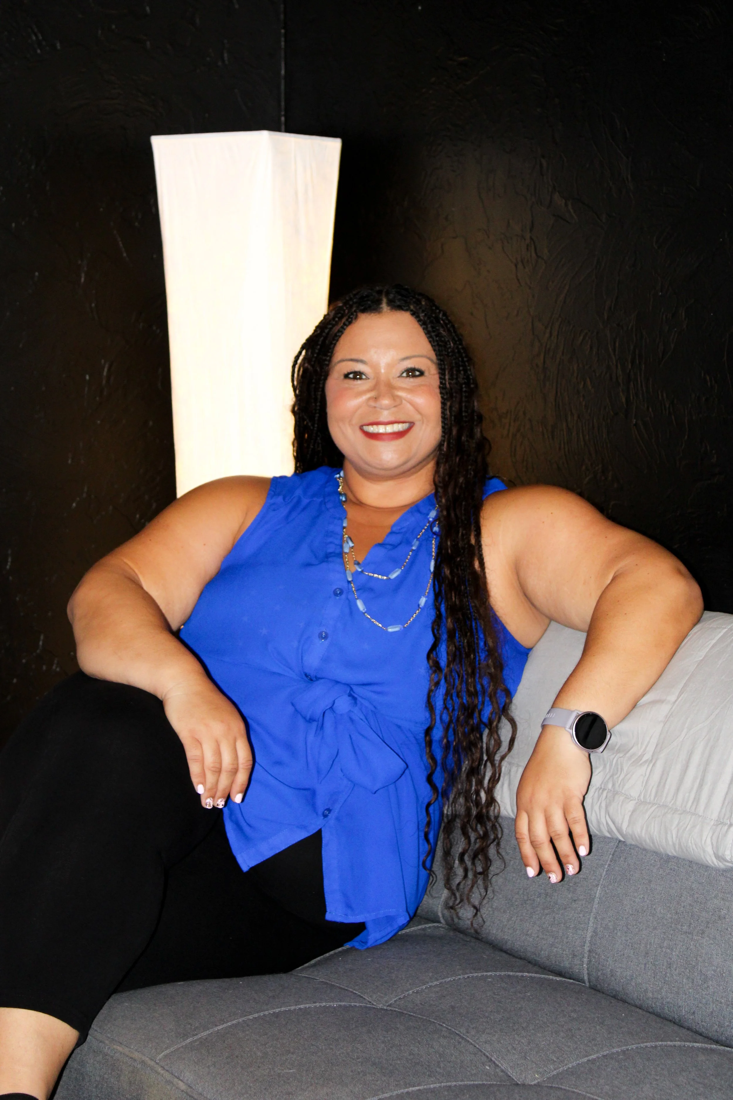 Woman in blue shirt sitting on couch