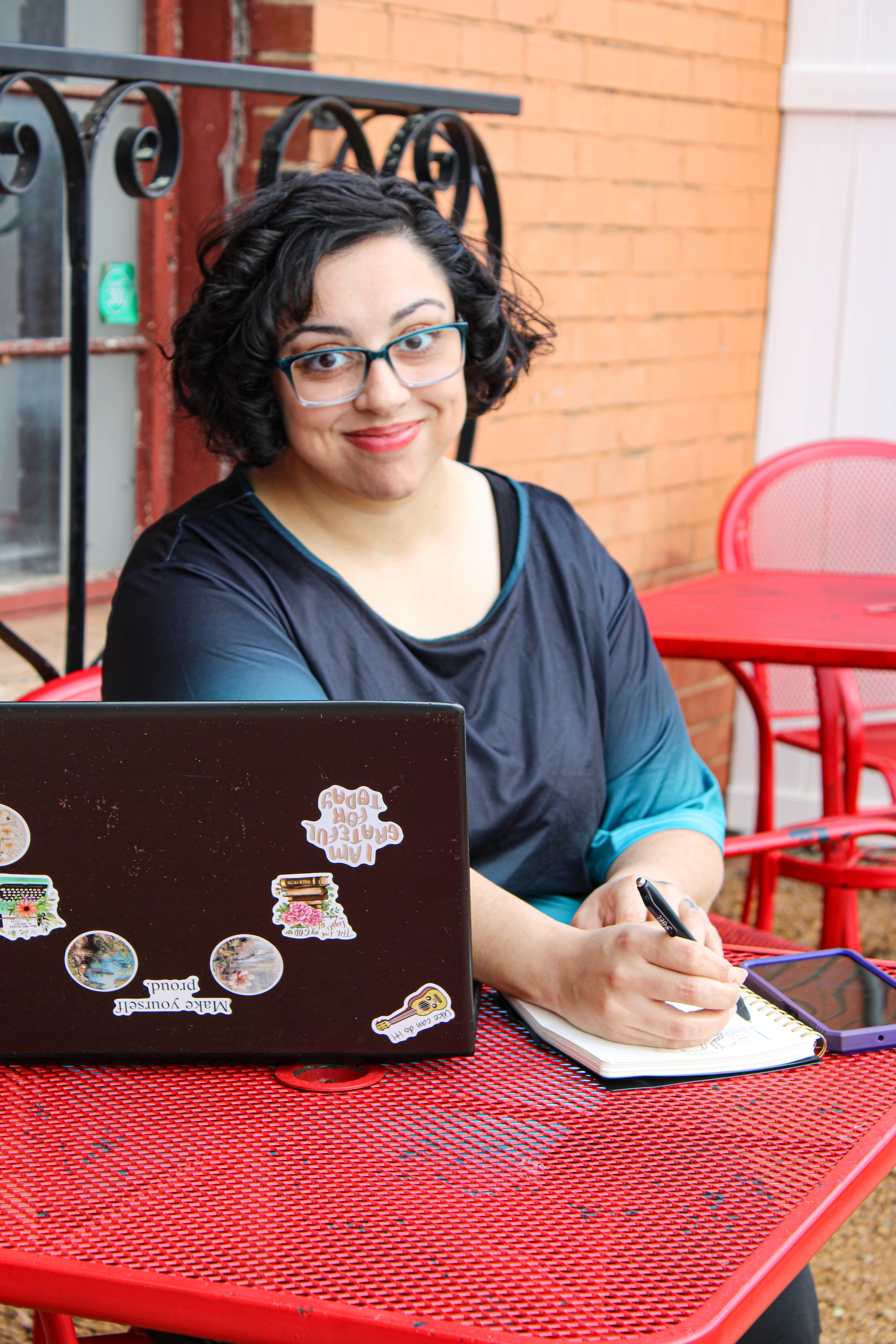 Woman sitting at computer on red table