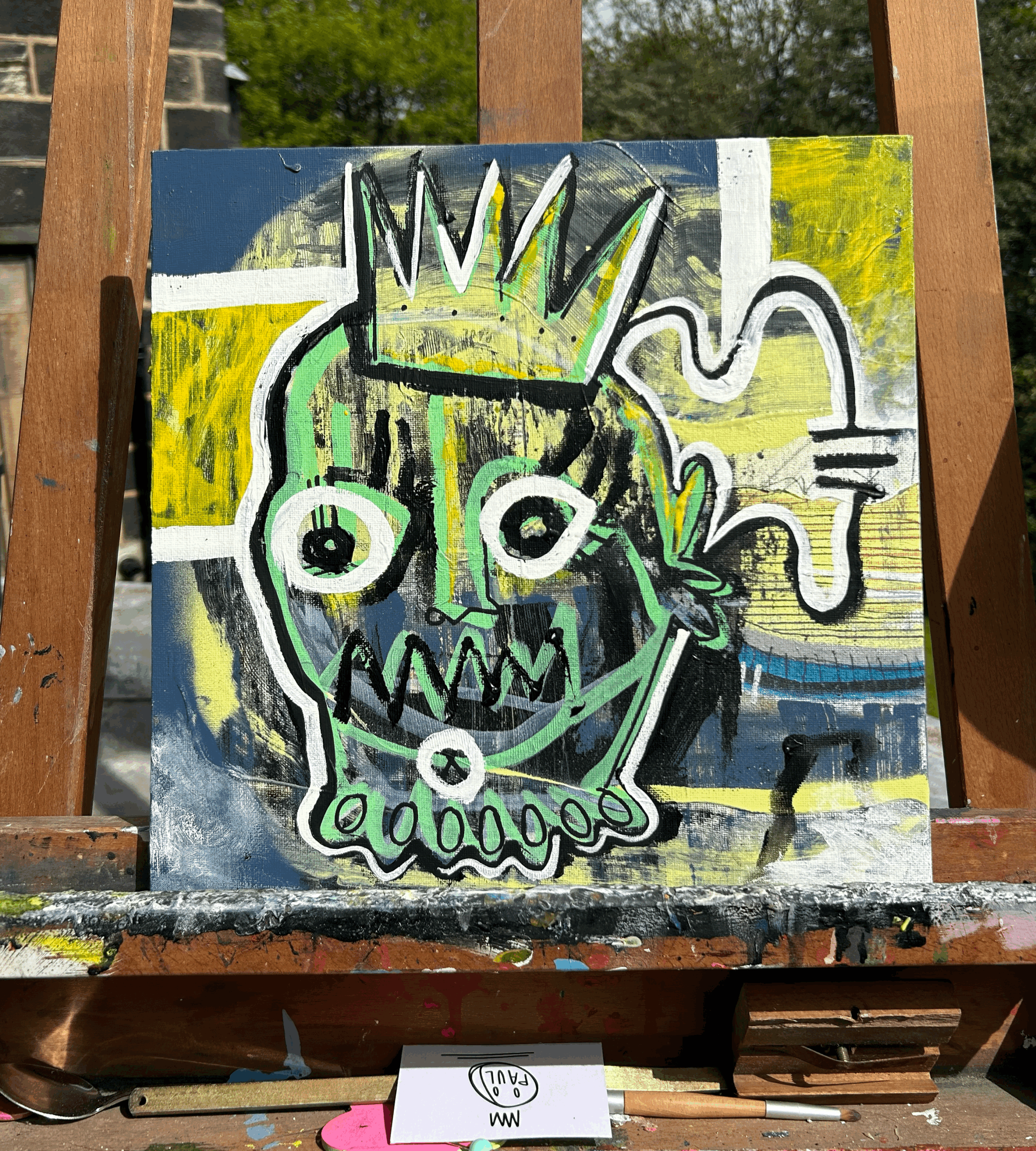 A colorful abstract painting featuring a stylized face with a crown, large eyes, sharp teeth, and various geometric shapes on a multicolored background.