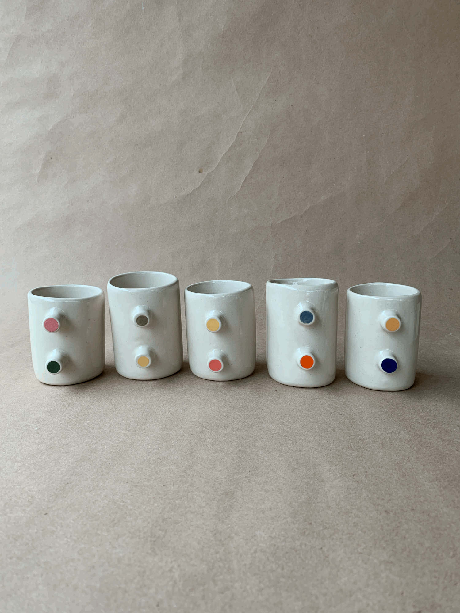 Five hand-thrown tumblers with colorful dots