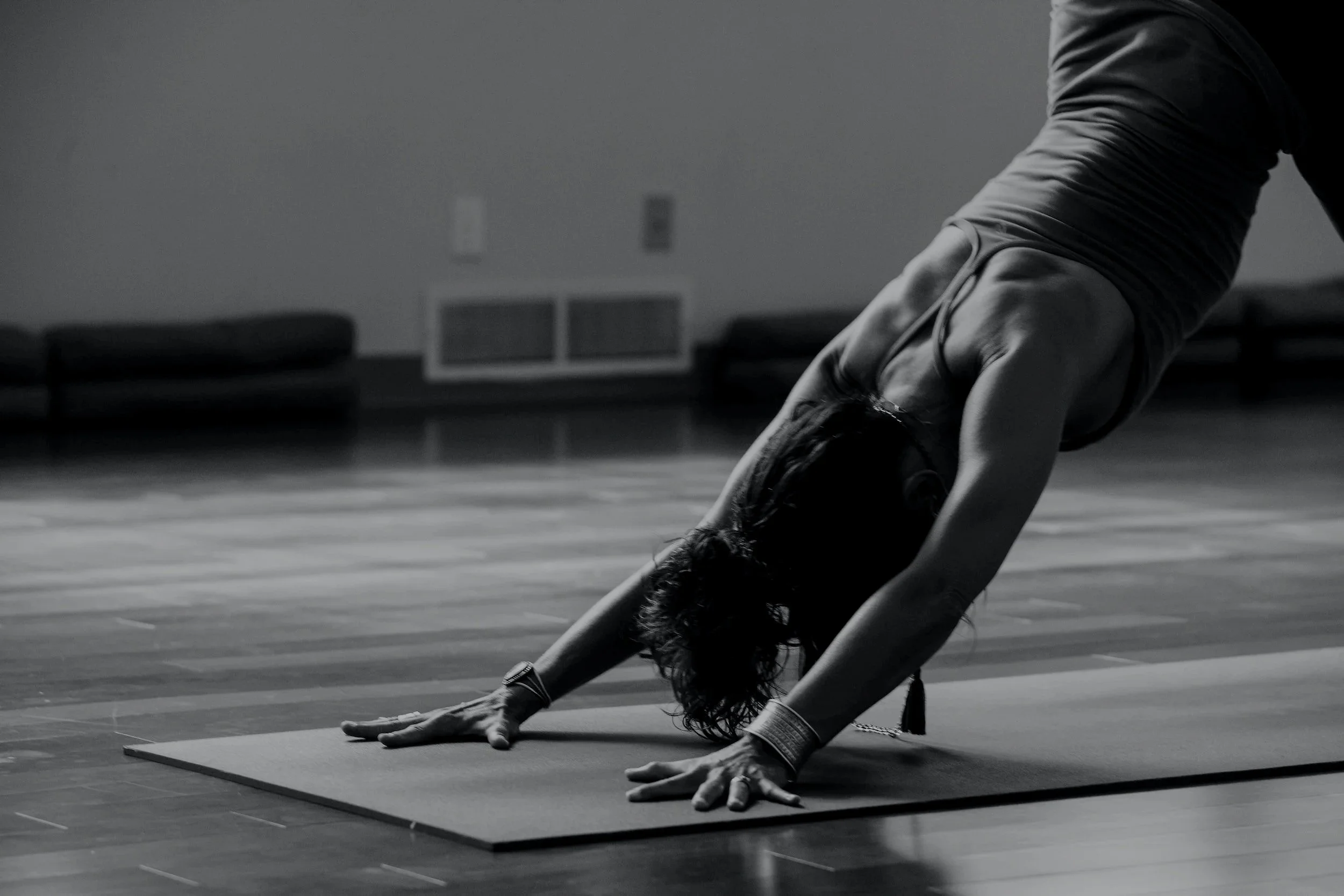 A woman holding down dog yoga pose on a yoga mat