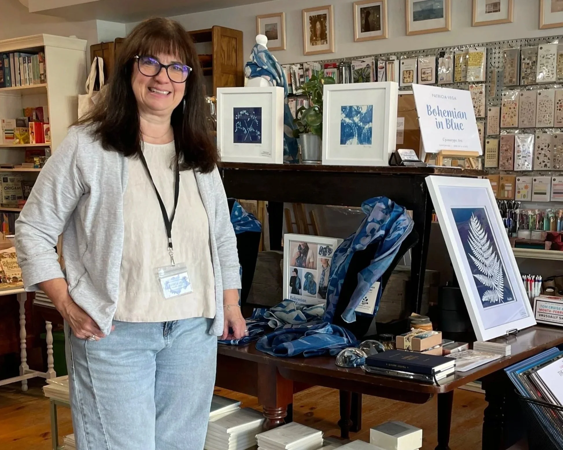 Patricia Vega beside her handmade cyanotype silk scarves at the Newsstand Store, showcasing her Bohemian in Blue collection.