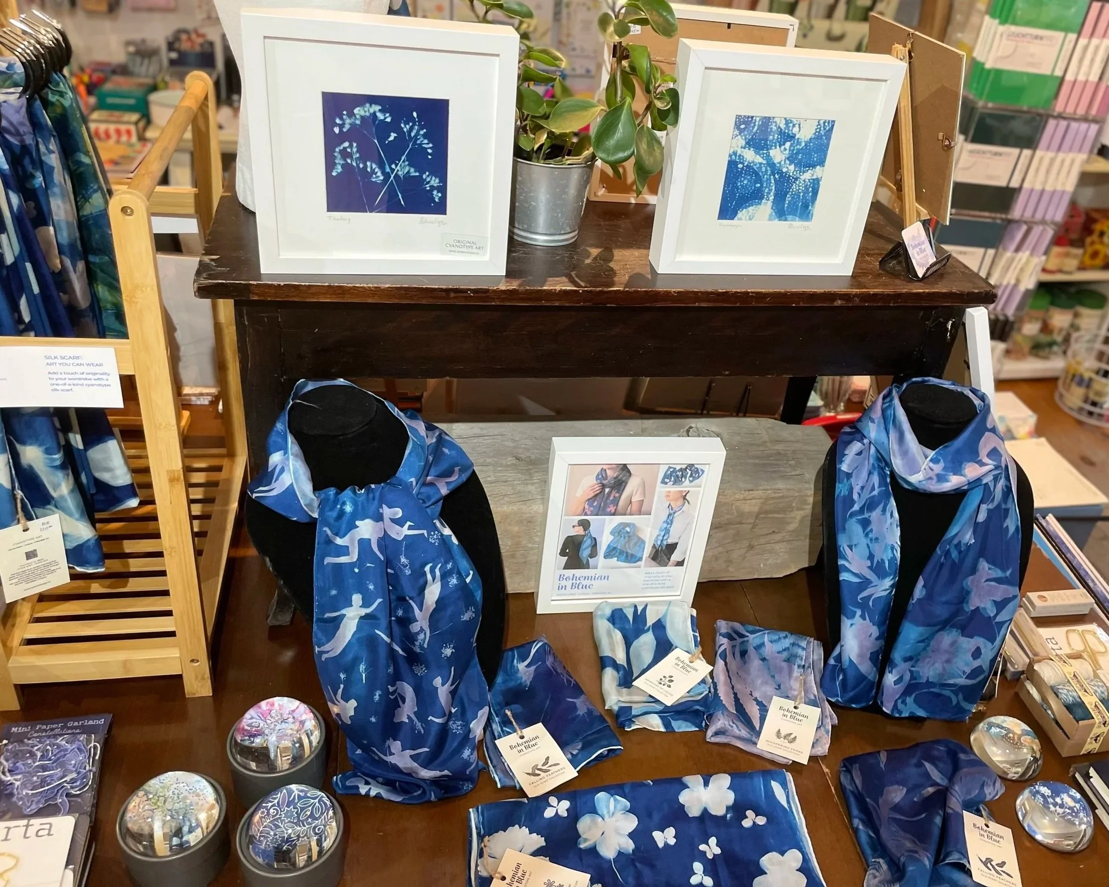Cyanotyepe scarves, cyanotype mini prints frames and paperweights displays on a table at The Newsstand Store.