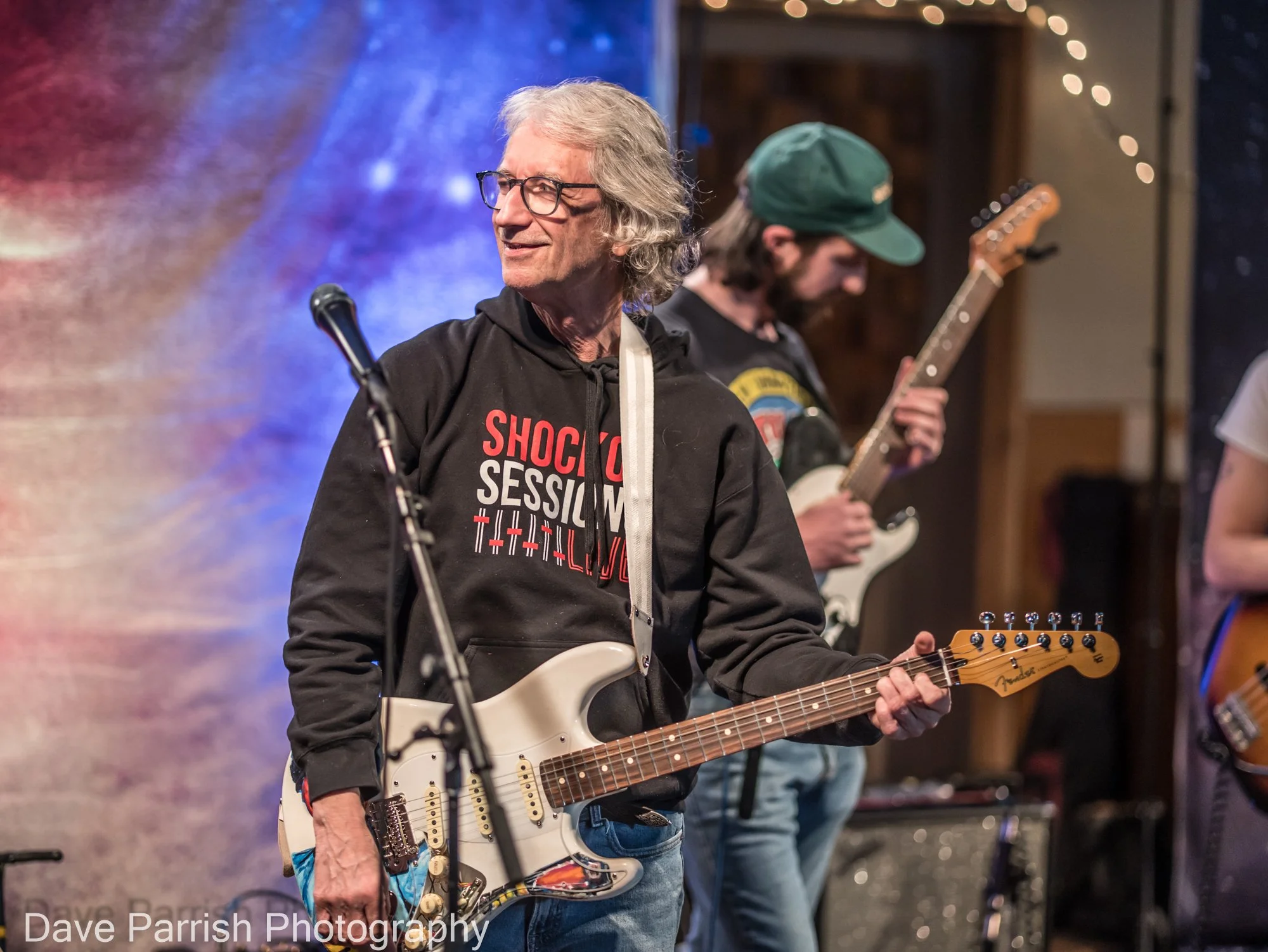 A man standing on a stage with a guitar