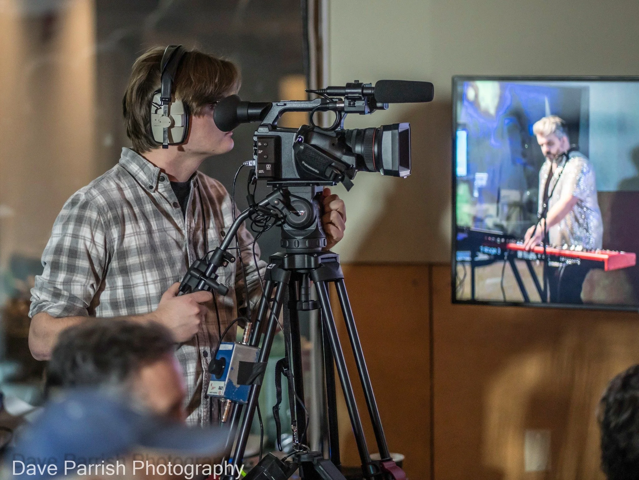 A man looking into a video camera sight.