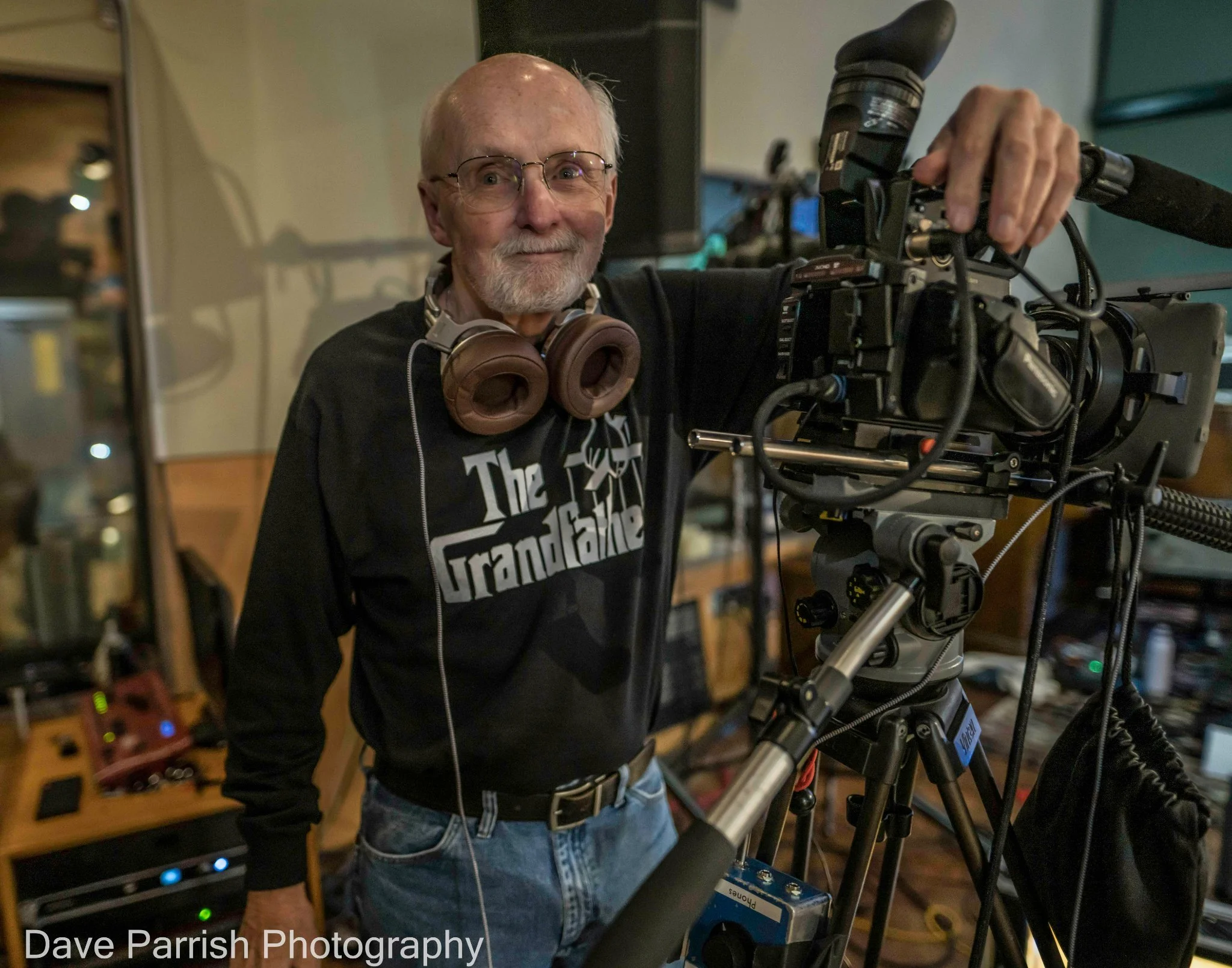 A man with headphones and a video camera.