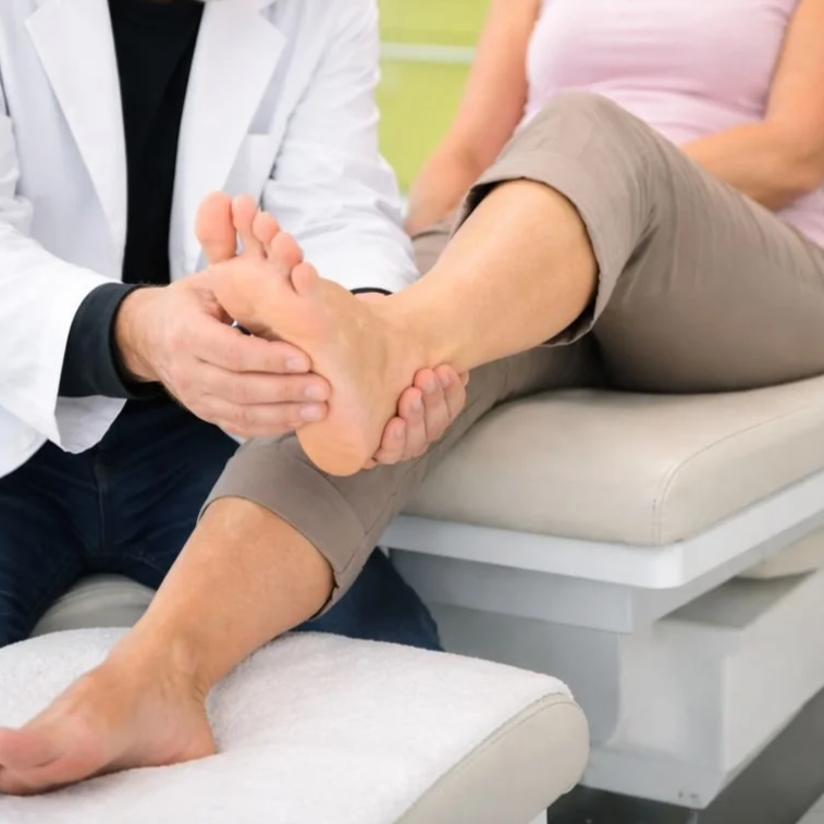 Scenic landscape with a large lake, rolling grassy hills, and tall mountain range under cloudy sky.