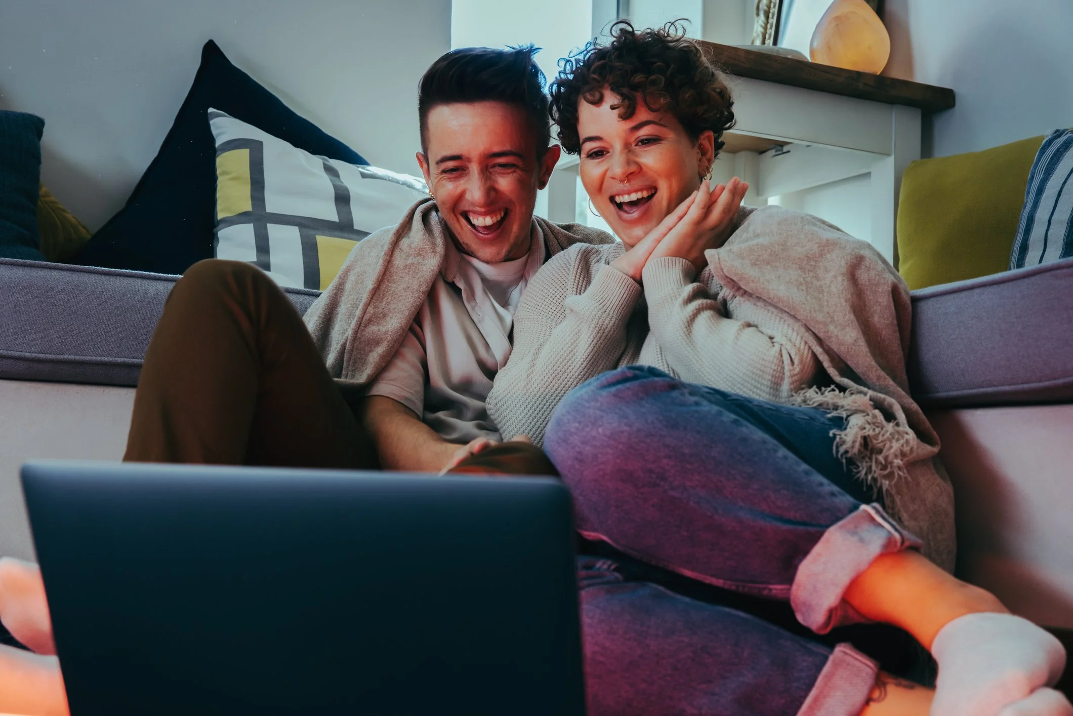 two people looking at a laptop and smiling