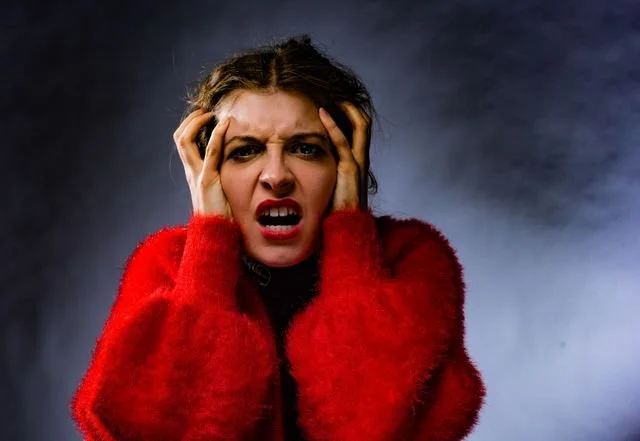 A woman in a red sweater looking angry