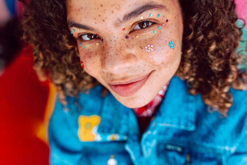A person smiling with glitter on their face