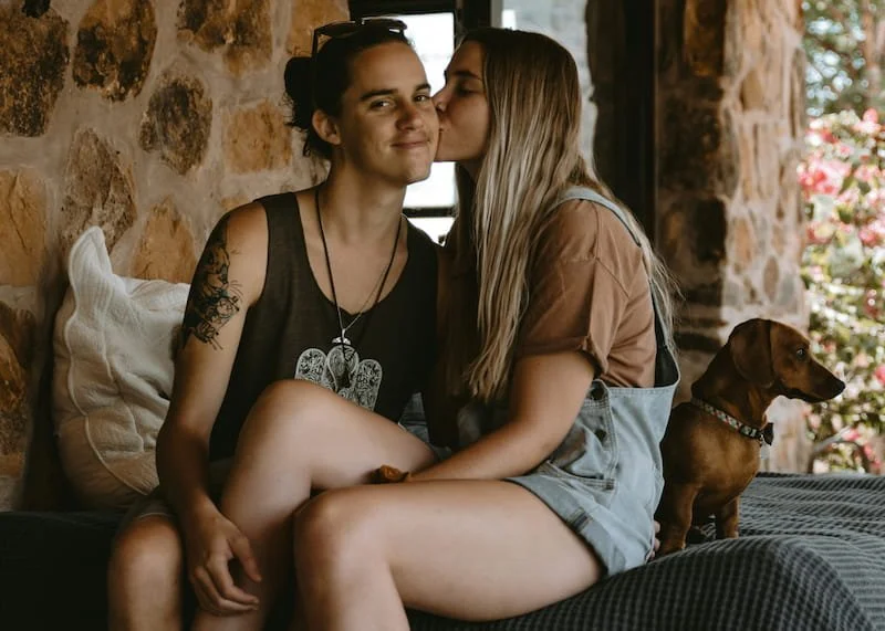 a couple smiling and one is kissing the other