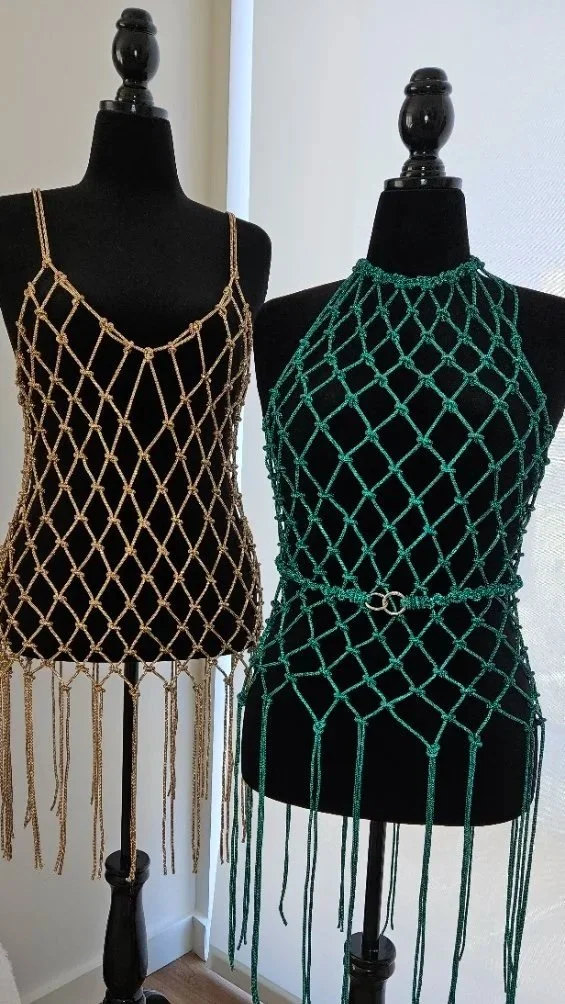Two macramé fringe dresses on mannequins showcasing intricate knotwork and statement silhouettes
