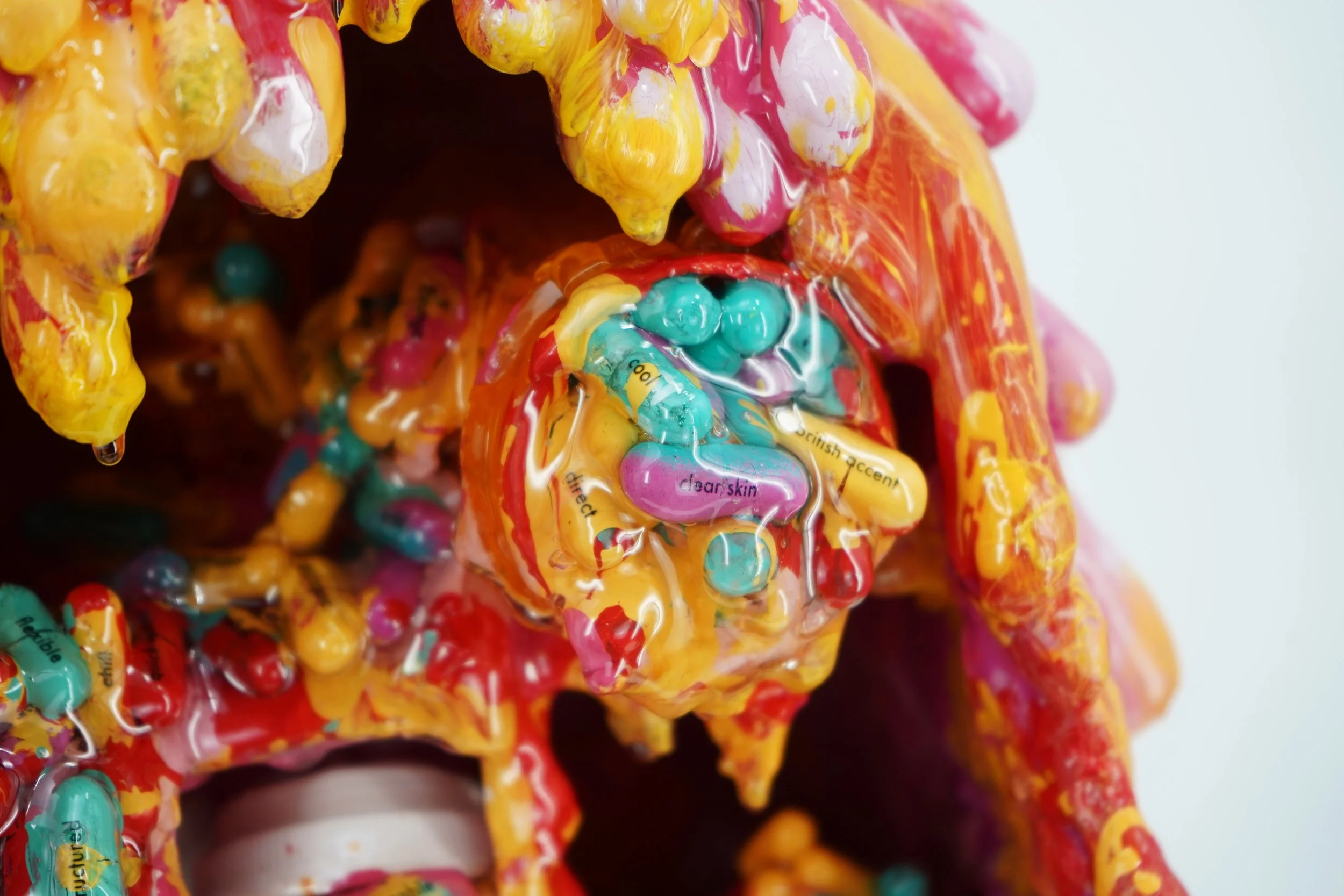 Detail view of melting medicine cabinet sculpture by contemporary artist Sophia Huang, mixed media sculpture with resin, paint, and embedded pill capsules