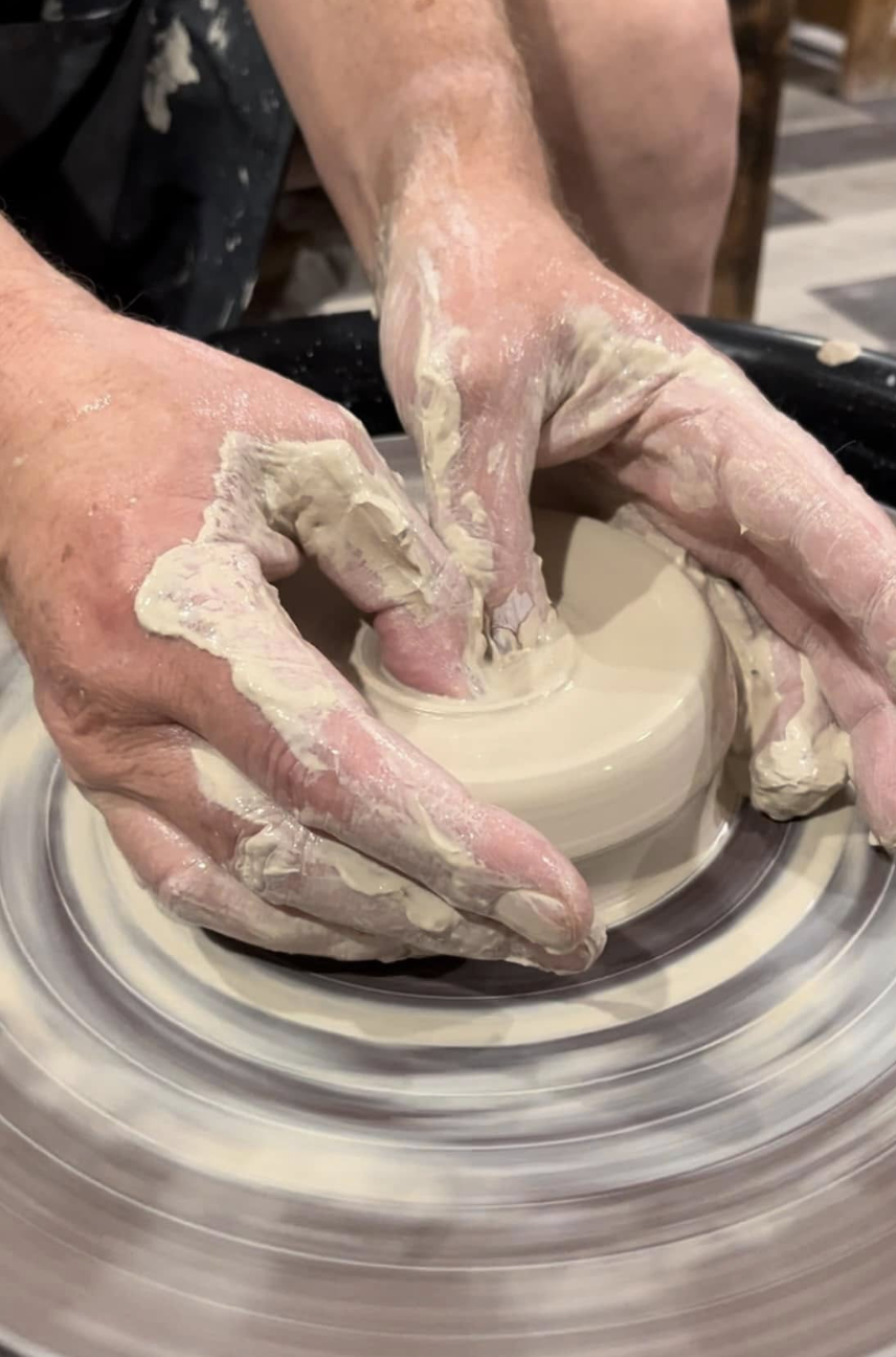 Person holding a leaf-shaped, cream-colored dish with carved vein details.