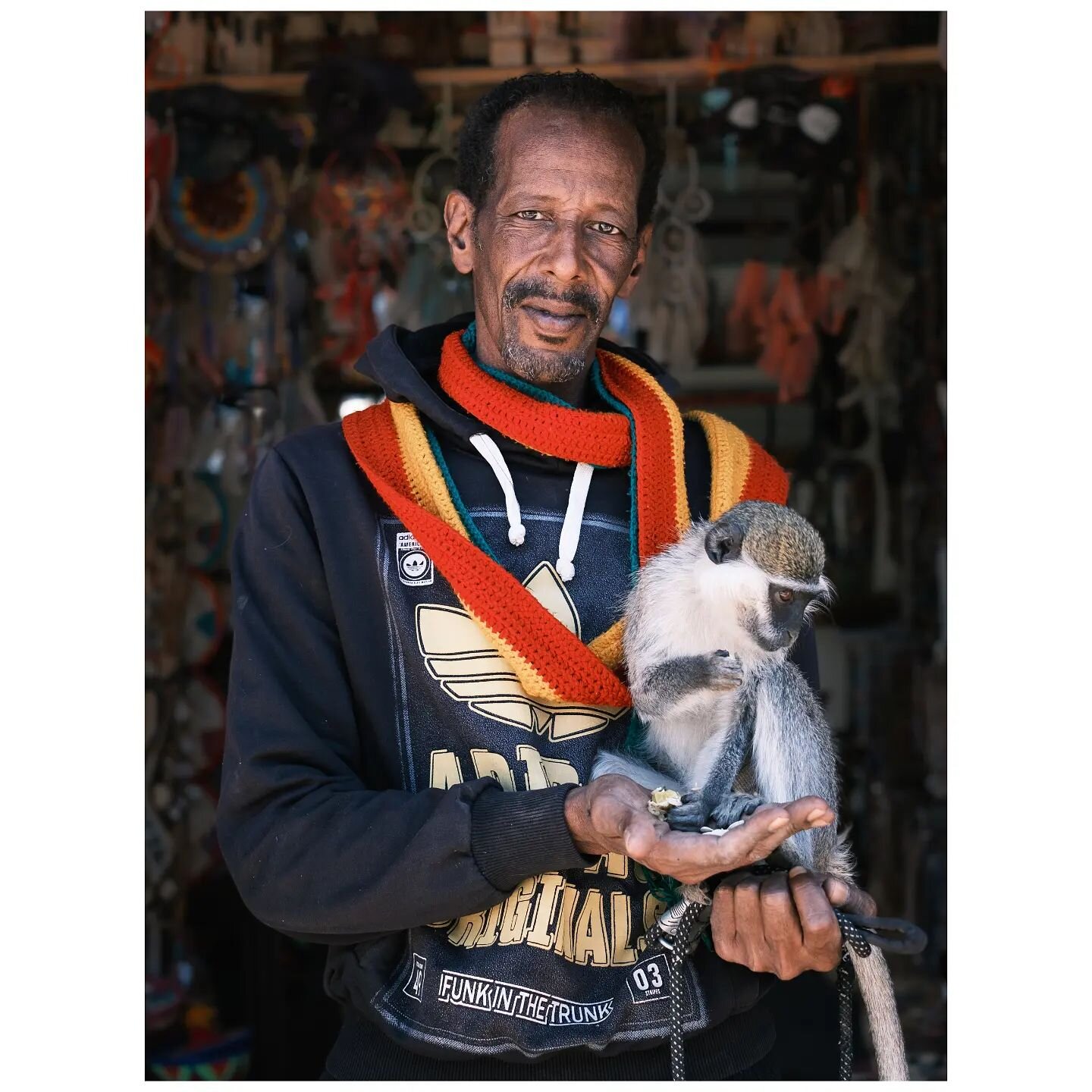 Man's best friend.

There is so much that I love about this photo, the man's eyes are striking, the colours of the Nubian artwork behind him, and of course, he's holding a monkey.
.
.
.
.
.
. 
#fujifilm #fujifilmxh2 #people #portraitsfromtheworld #fu