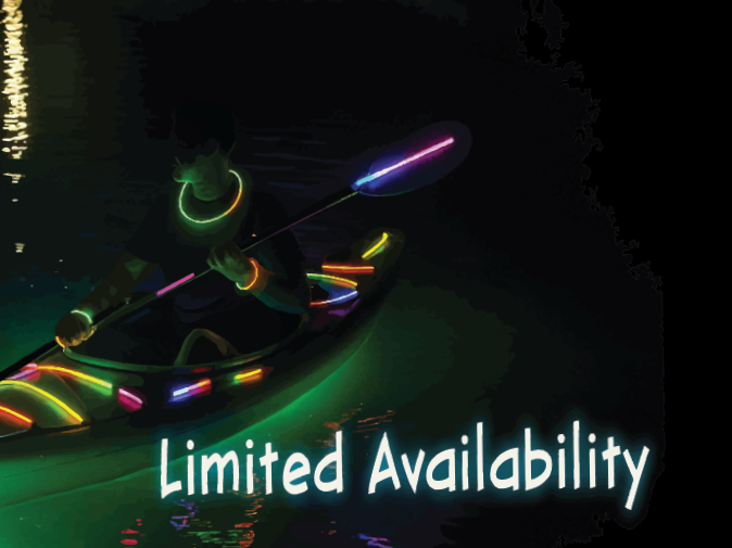 Person kayaking at night decorated in glow sticks and glow bracelets