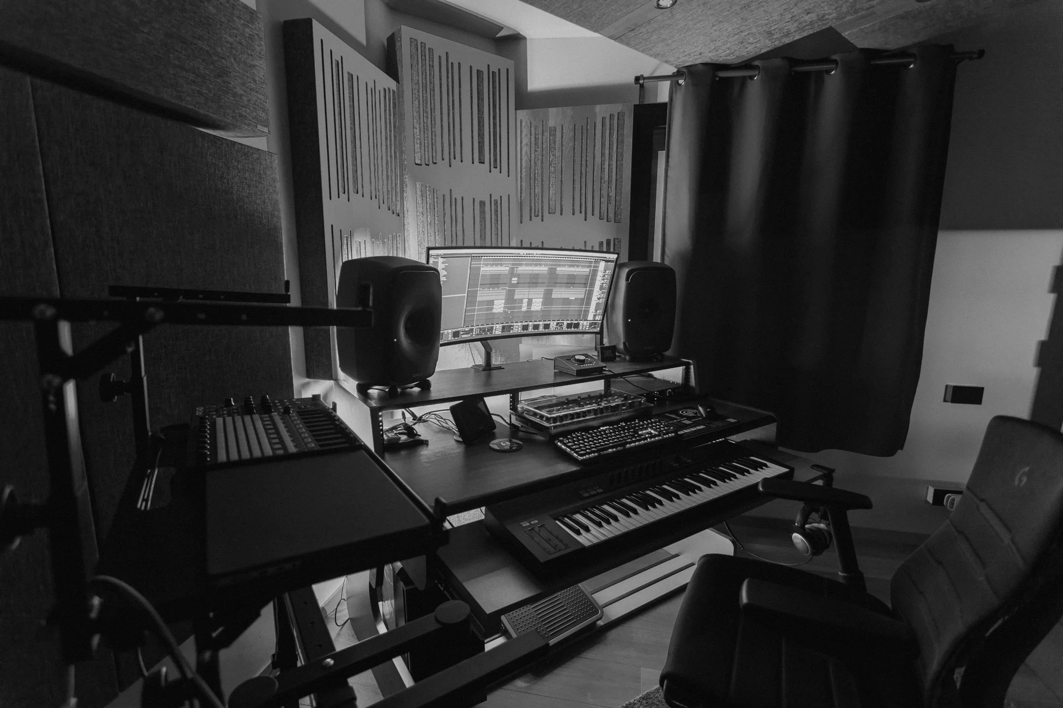Matteo Tura's music studio with a computer monitor, speakers, MIDI keyboard, and mixing console, black and white photo.