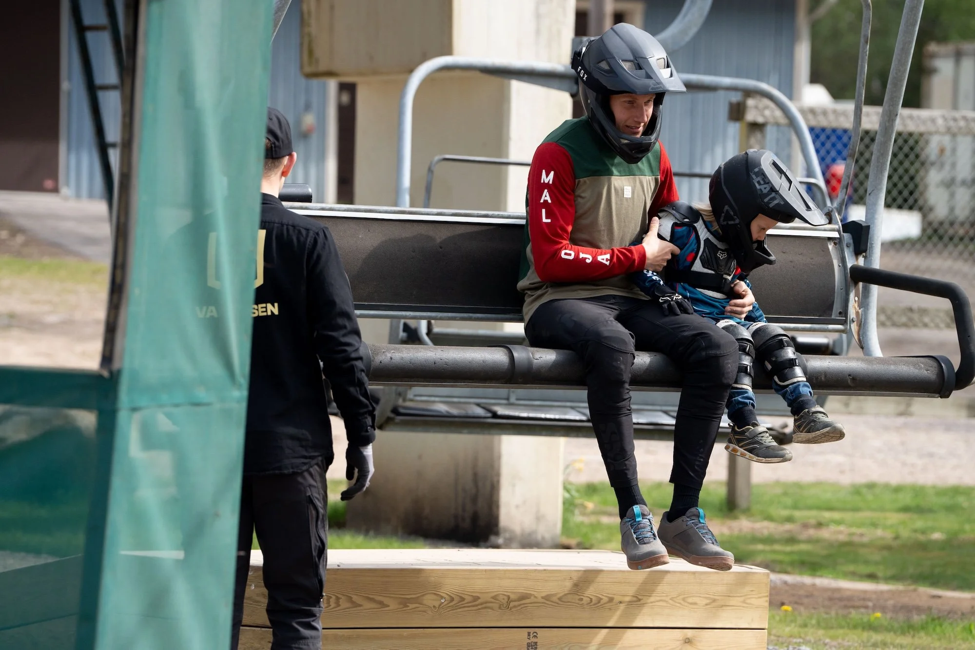En vuxen och ett barn i cykelkläder i sittliften på Vallåsen Bike Park.