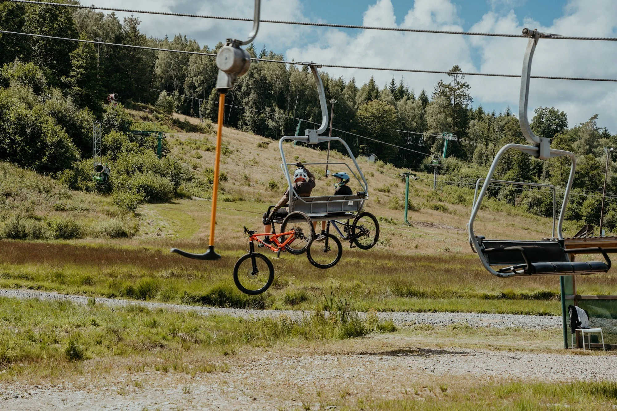 Två personer åker lift upp till toppen av Hallandsåsen på Vallåsen Bike Park.
