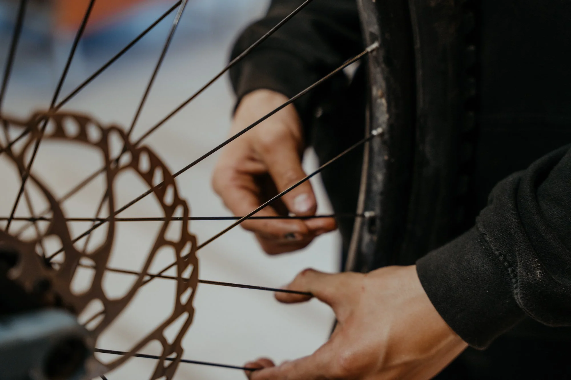 Person som justerar mountainbikedäck, fokus på händer och cykelns hjul.