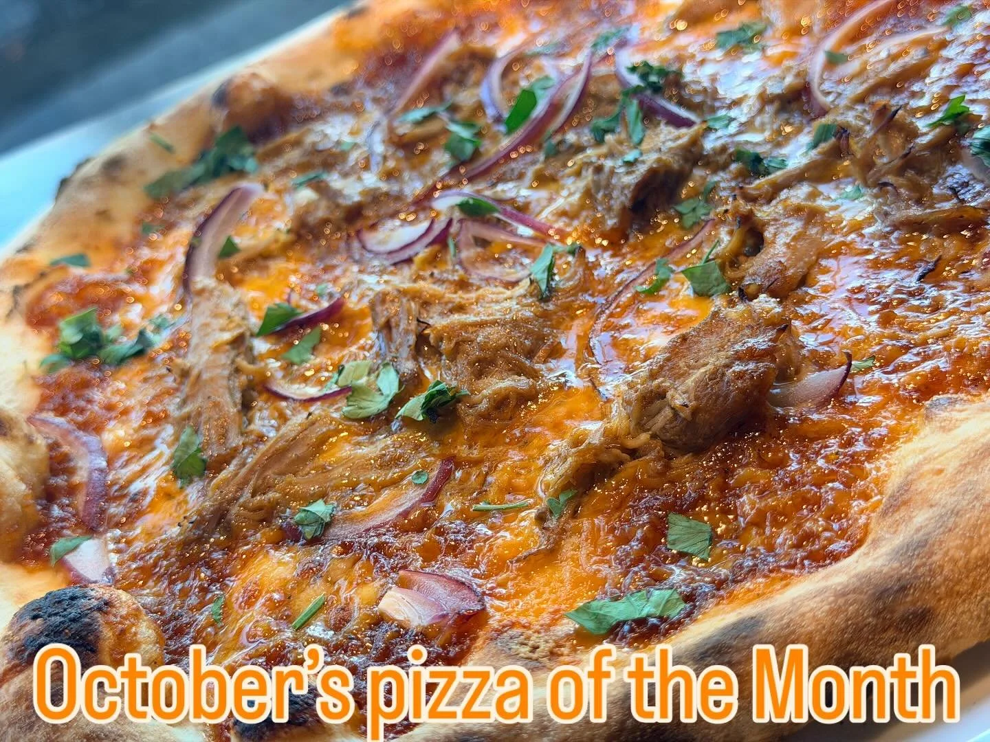 October&rsquo;s Pizza is made with Slow-cooked pulled pork on a base our house made with BBQ sauce, topped with roasted red onions and a rich blend of Cheddar and Gouda cheeses , all made by Bobby while listening to a little country music