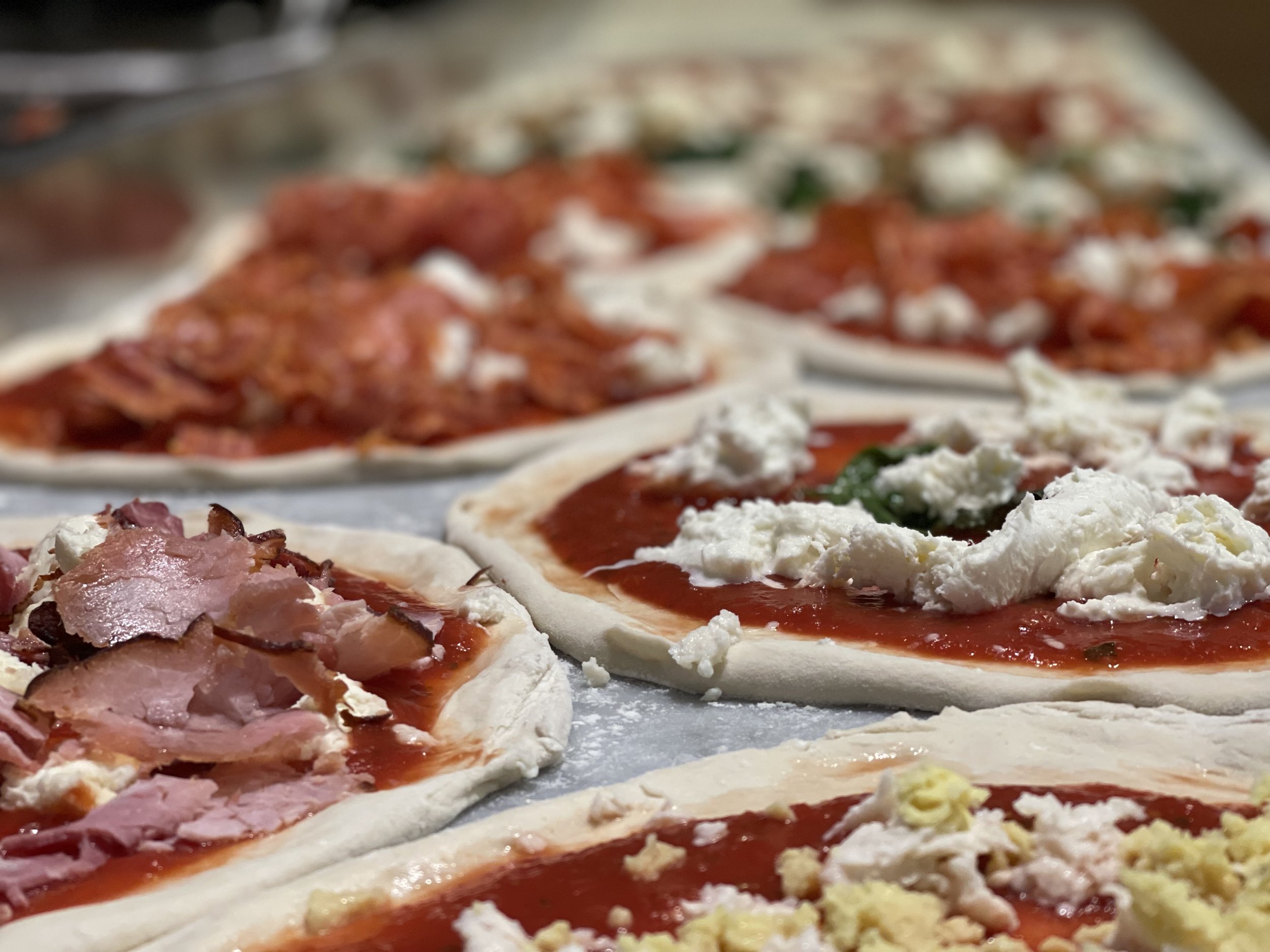 A marble slab full of Pizza about to go into the oven 