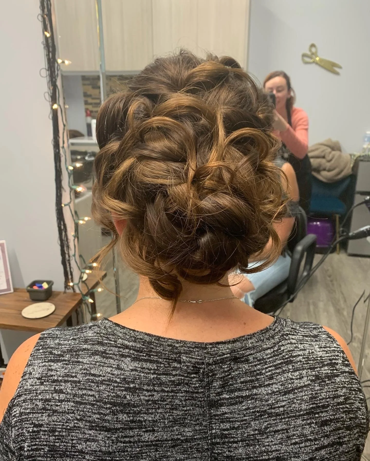 Intricate braided updo on a woman in a hair salon