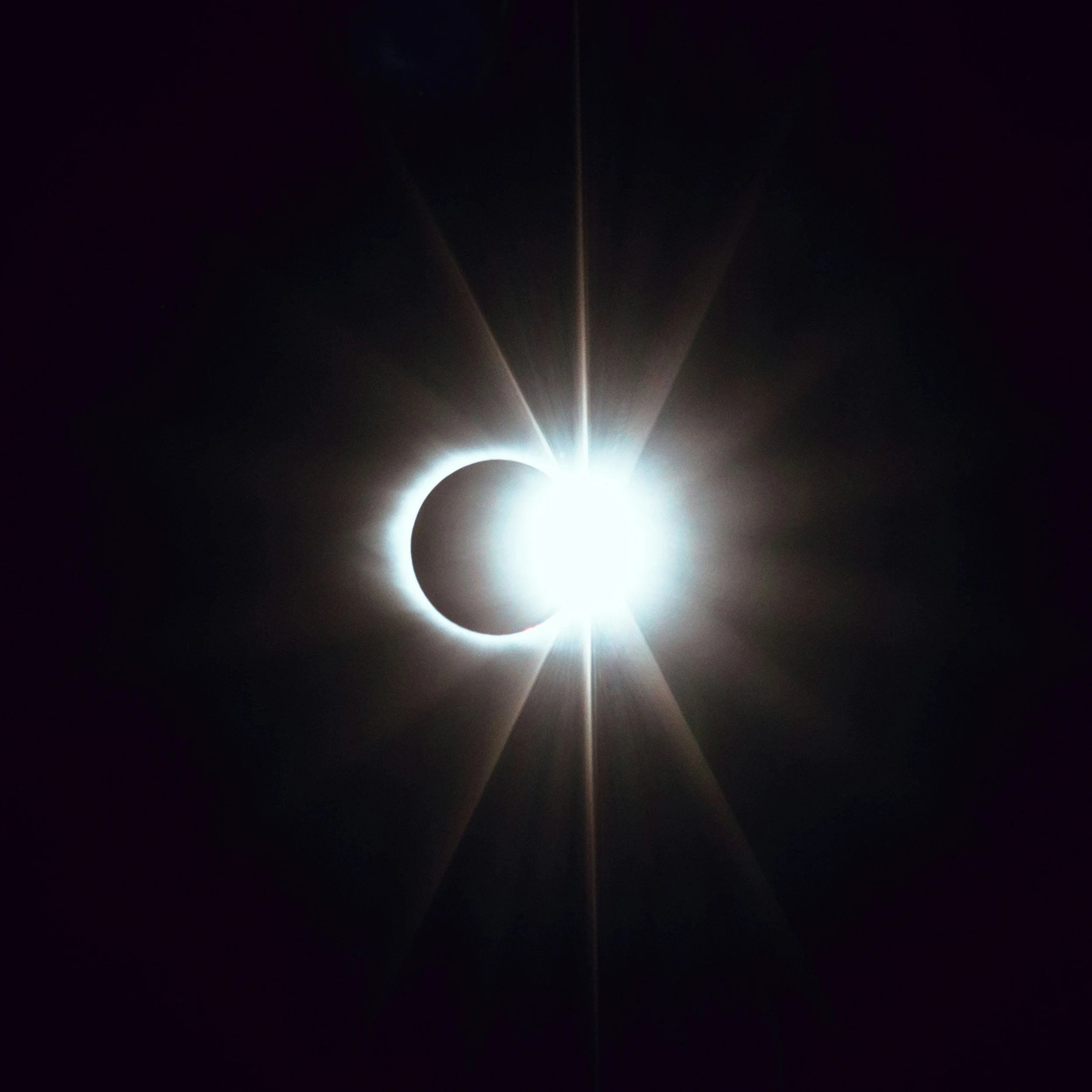 Solar eclipse with the moon blocking the sun and the sun's corona visible around the moon.