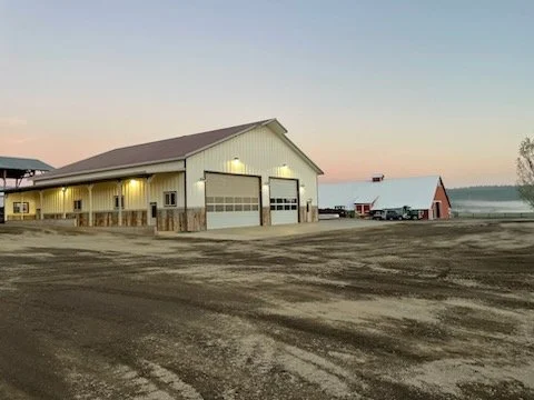 Scenic view of a turquoise lake surrounded by mountains under cloudy sky in a grassy landscape.