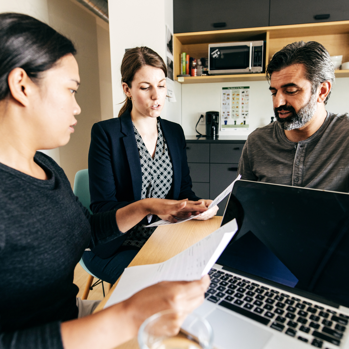 People reviewing financial paperwork with an advisor: what a charge-off means for your credit
