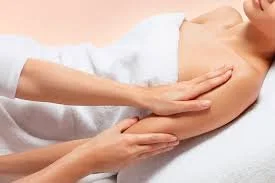 Person receiving a massage on the arm in a spa or massage setting.