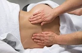 Someone giving a massage to a person's lower back.