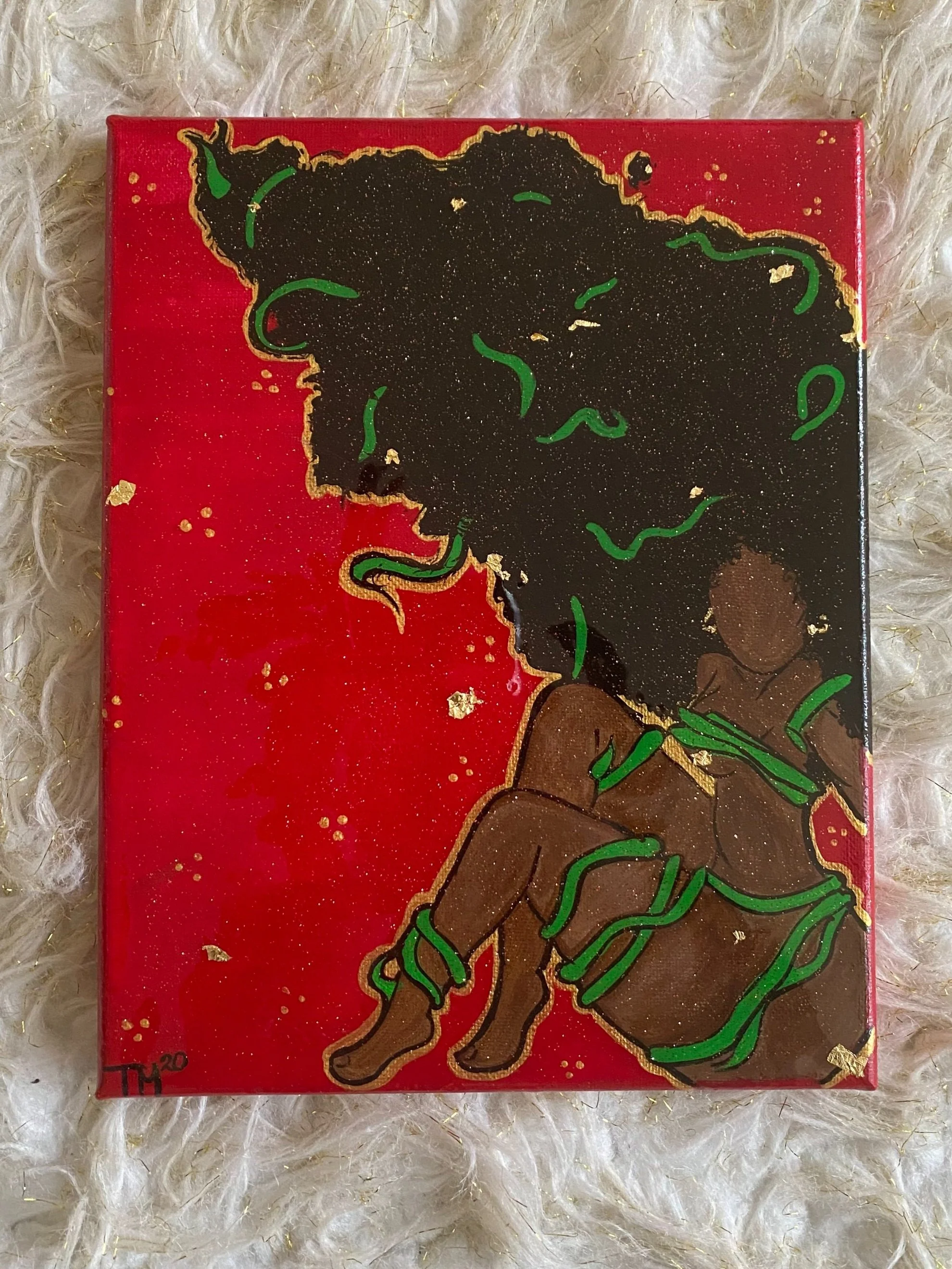 A colorful painting of a woman with natural afro hair, outlined in gold, sitting with her eyes closed against a red background with gold specks, and a small child sitting beside her, wrapped in green handprints.