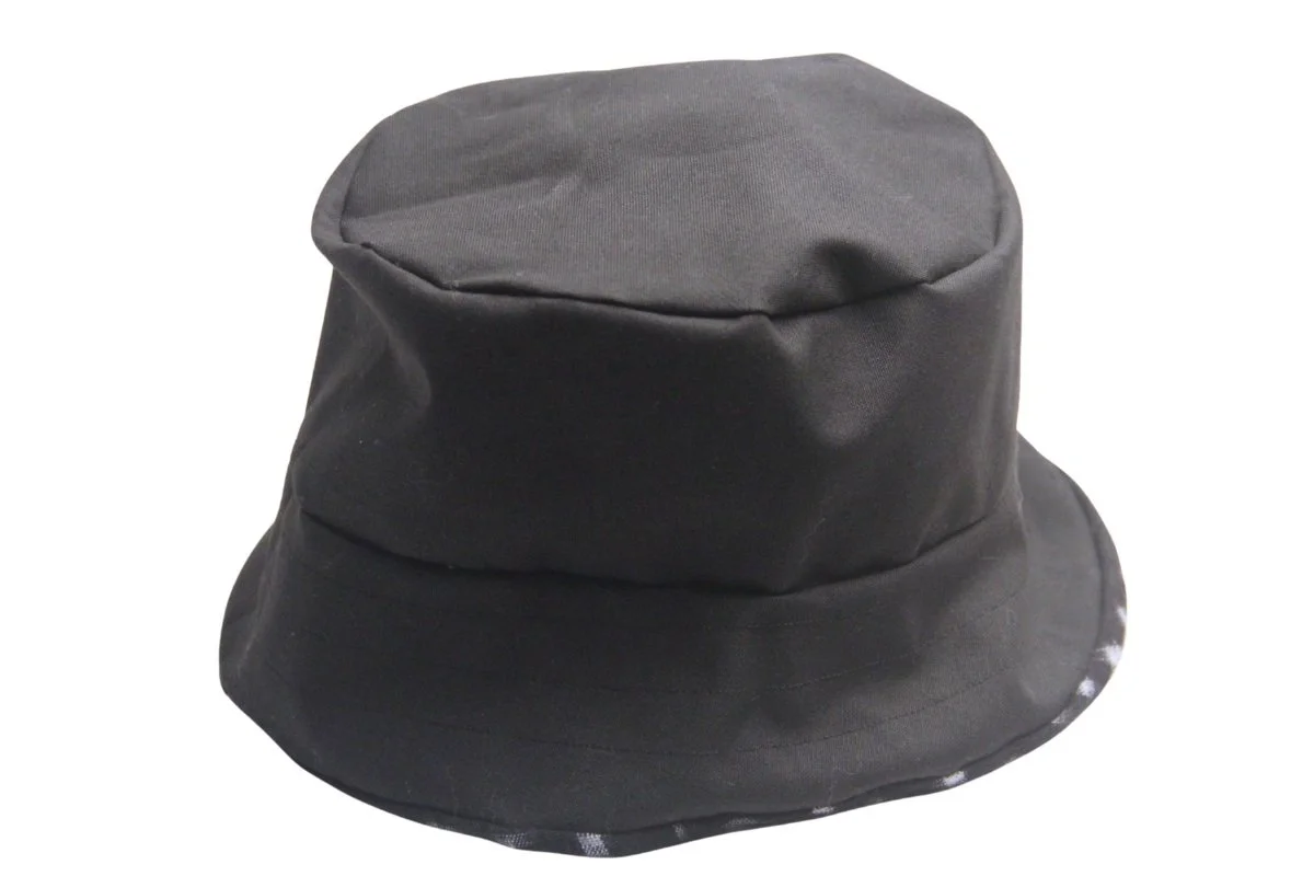Black cotton duck cloth side of our reversible elevated bucket hat made from Japanese Ikat-dyed fabric in black and ivory pattern. Handmade by Tonya Gross Millinery.
