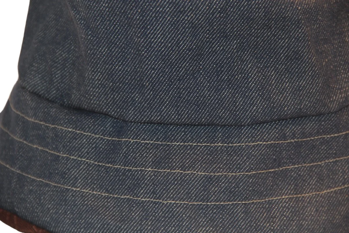 Close up of reversible denim on elevated bucket hat made from Japanese Morikiku jacquard cotton fabric. Reverses to a heavyweight vintage denim cotton. Made by hand - Tonya Gross Millinery.