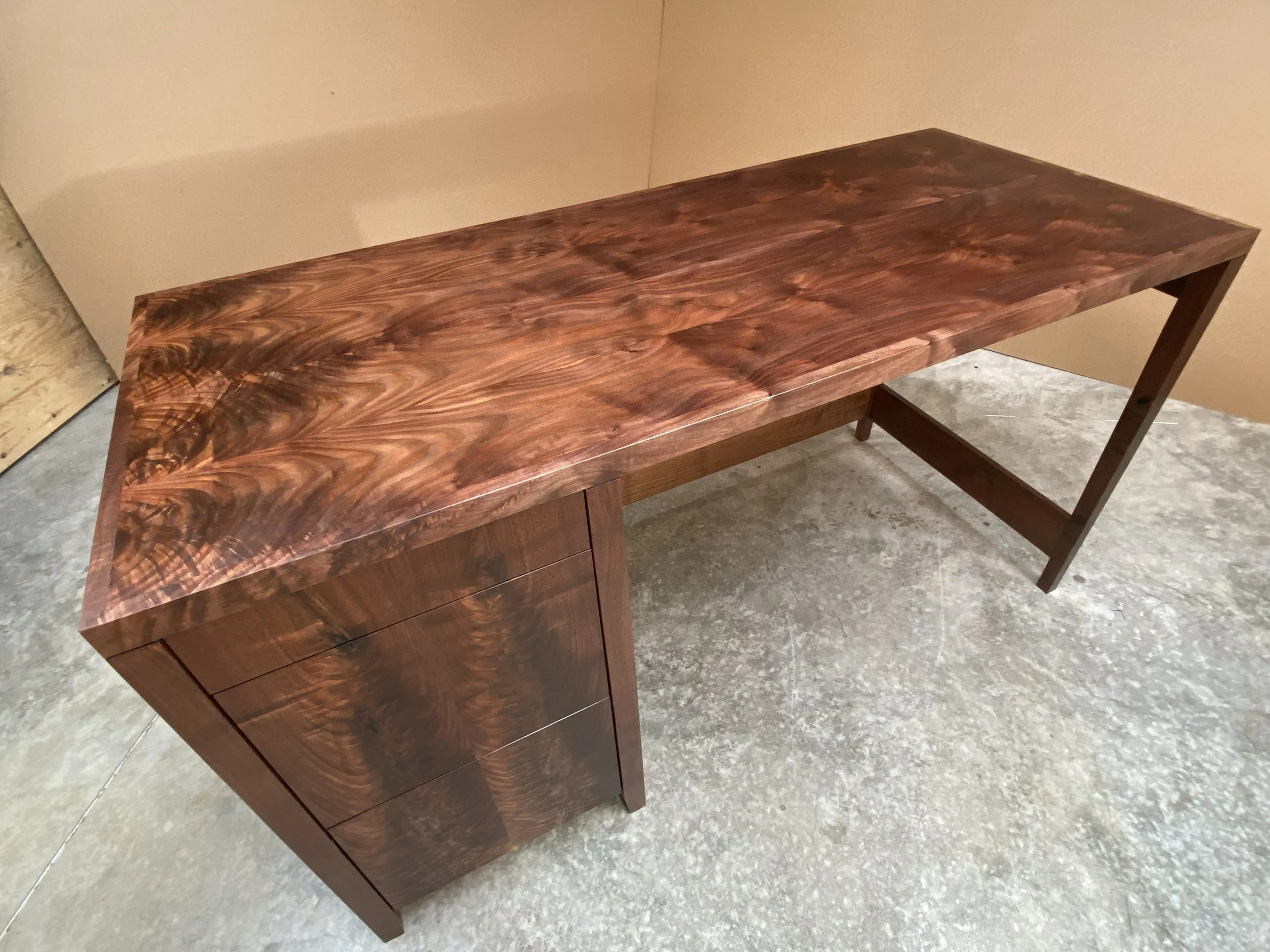 The top is 1-1/2 inches thick and made using a woodworking technique called "lumbercore". It produces a very stable and flat top.