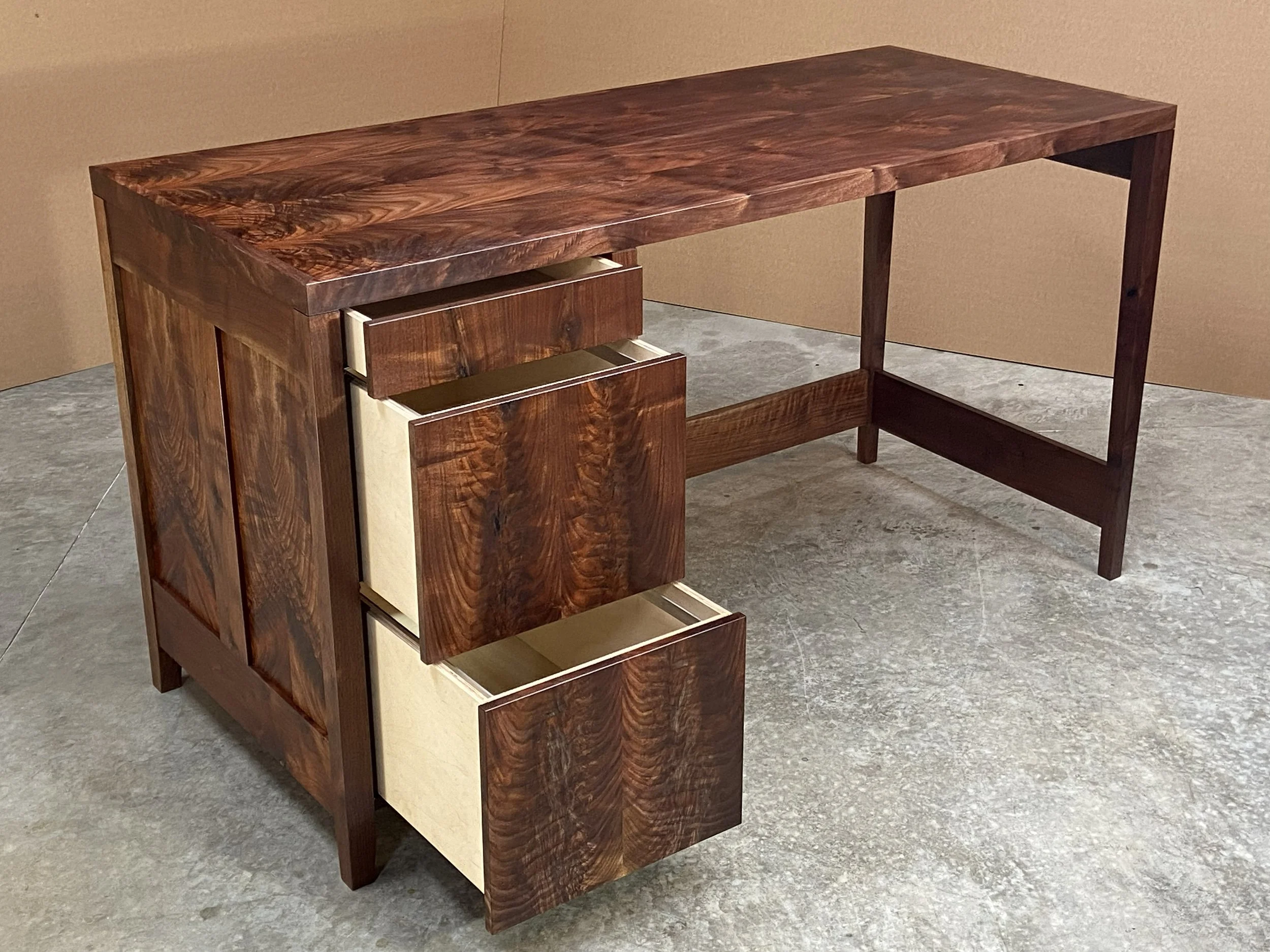 The desk features one flat drawer plus two file drawers.