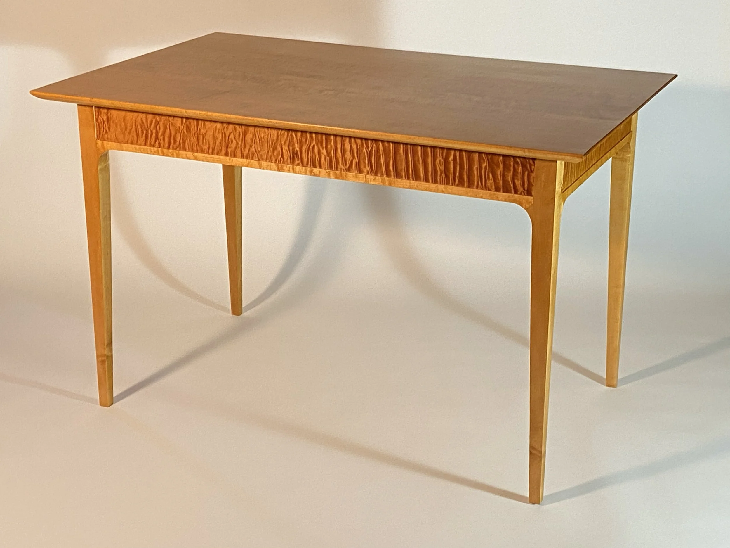 The lighting is changed to accentuate the apron's figured grain