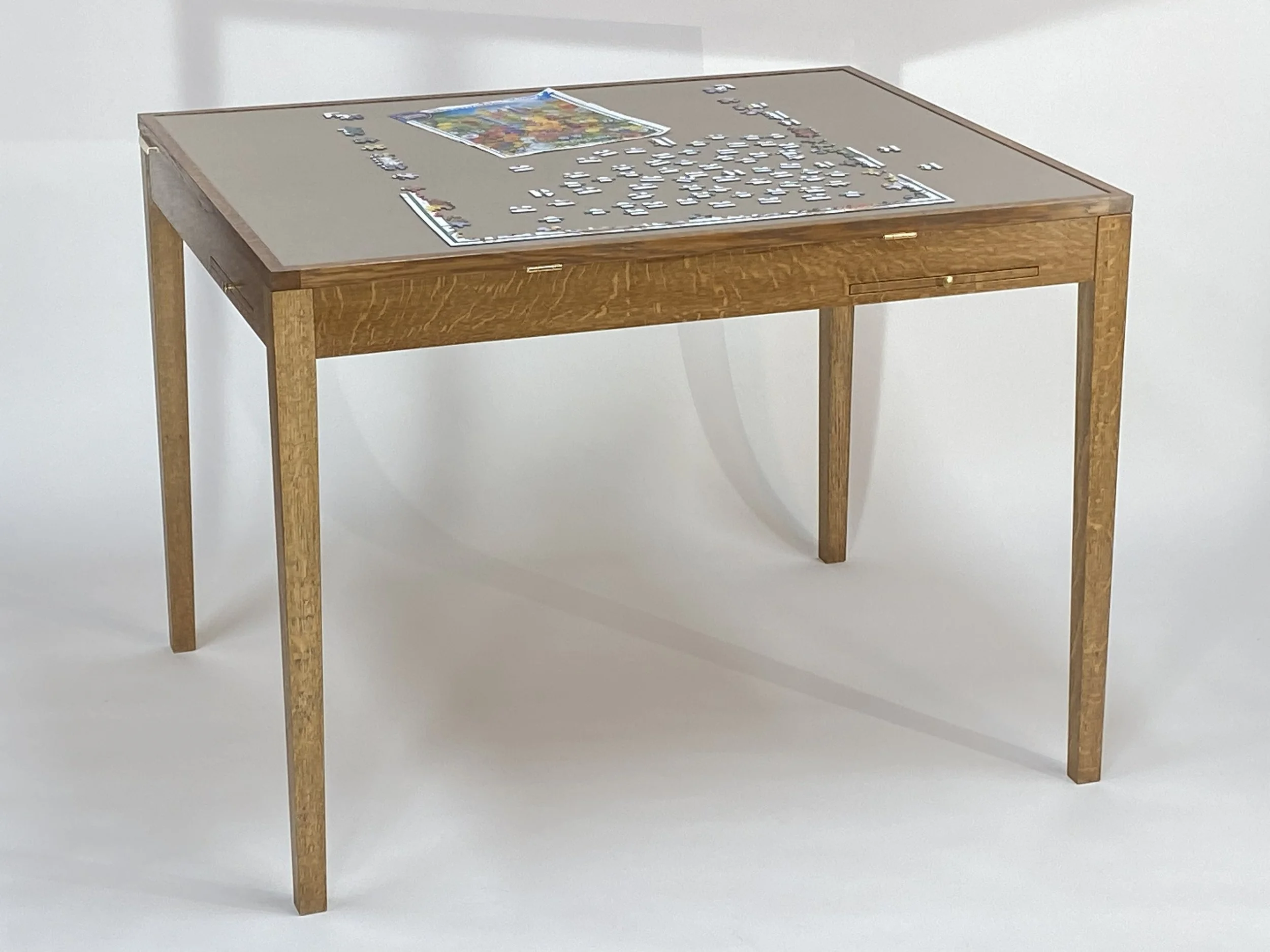 The jigsaw puzzle table is 40-1/2" wide x 32-1/2" deep x 30" tall with 26" of leg clearance. The wood is White Oak.