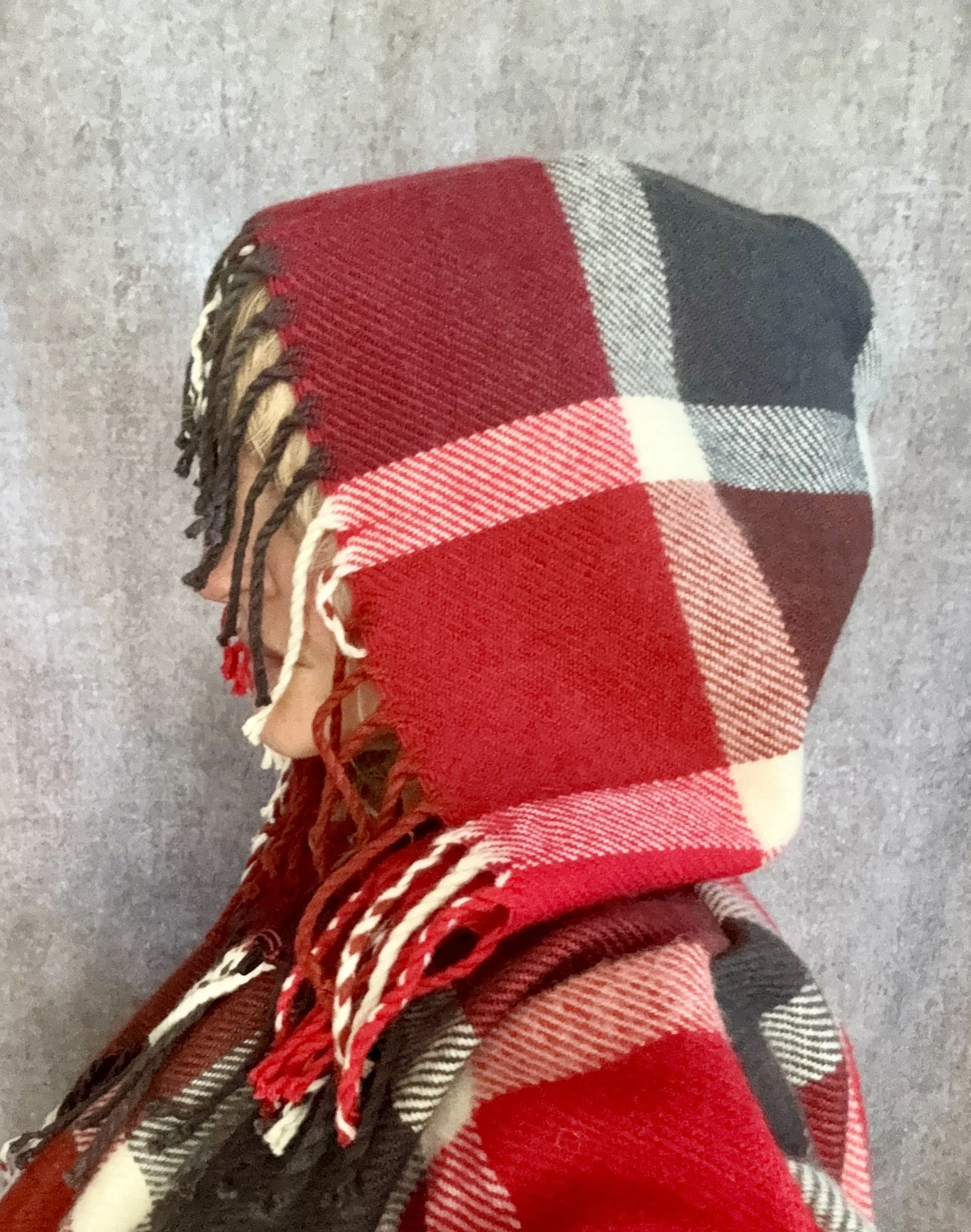 Side head view of a red plaid hooded jacket with fringe.