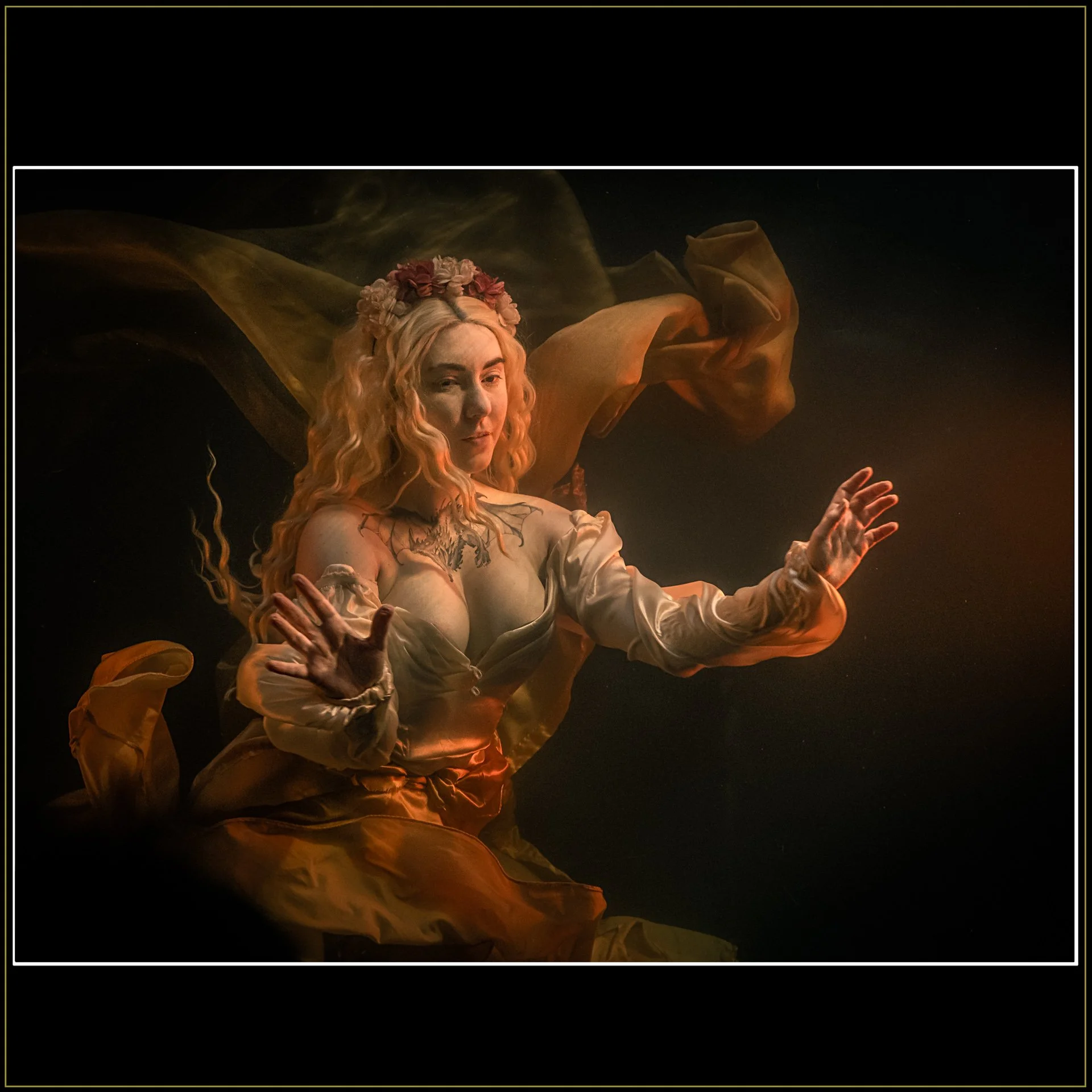 Liminal Drift Fantasy Photography by Catherine Knee. Ethereal underwater image of woman with flowing dress and soft golden light suspended in dark void-like space with drifting fabric.
