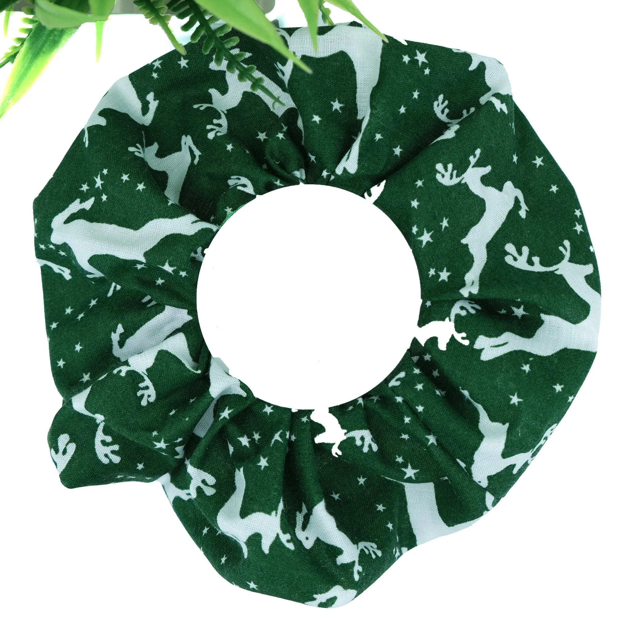 Handmade green Christmas scrunchie decorated with a white reindeer print, festive hair accessory by Creatoria Nyx