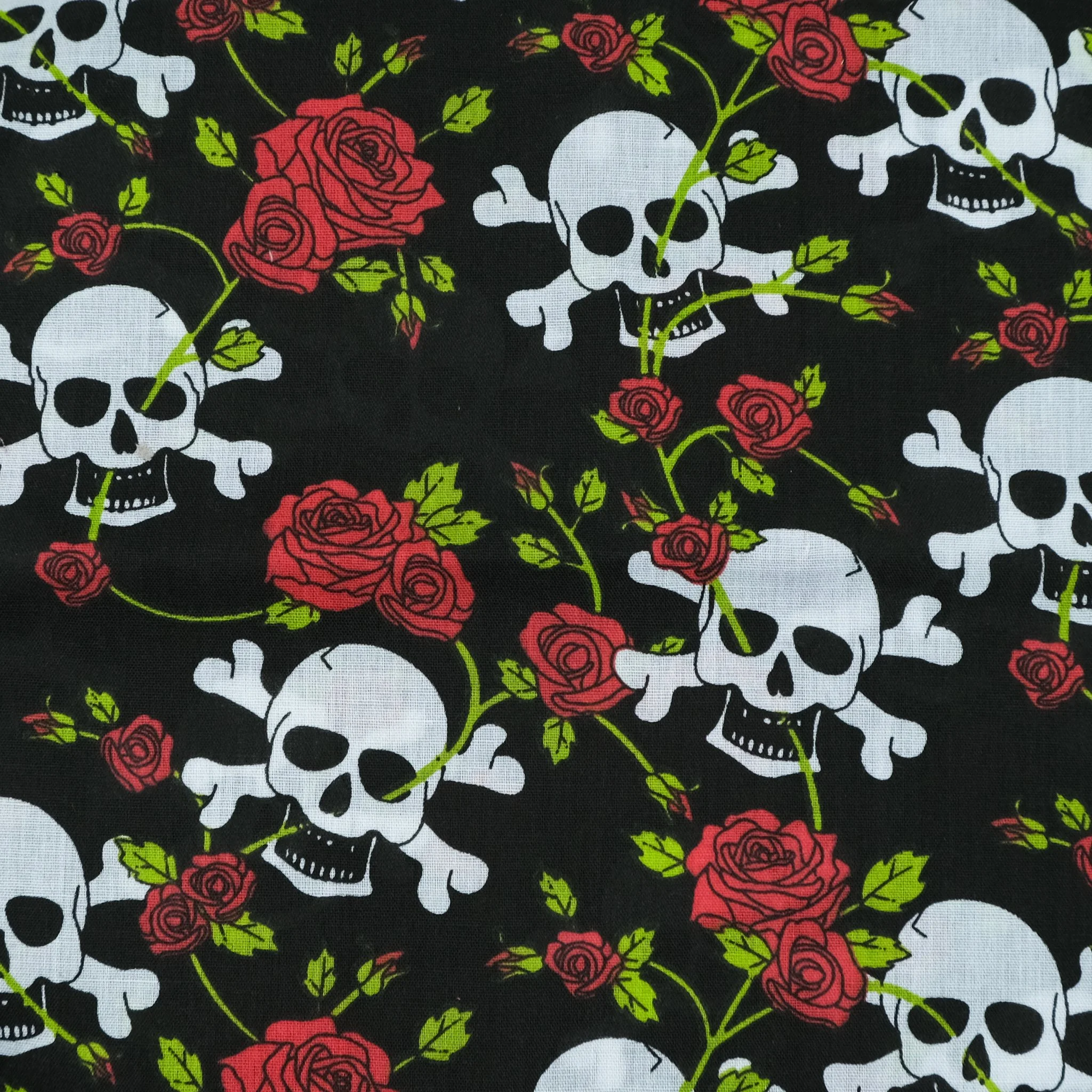 Black fabric with white skulls and red roses, used for handmade Axis Range scrunchie by Creatoria Nyx